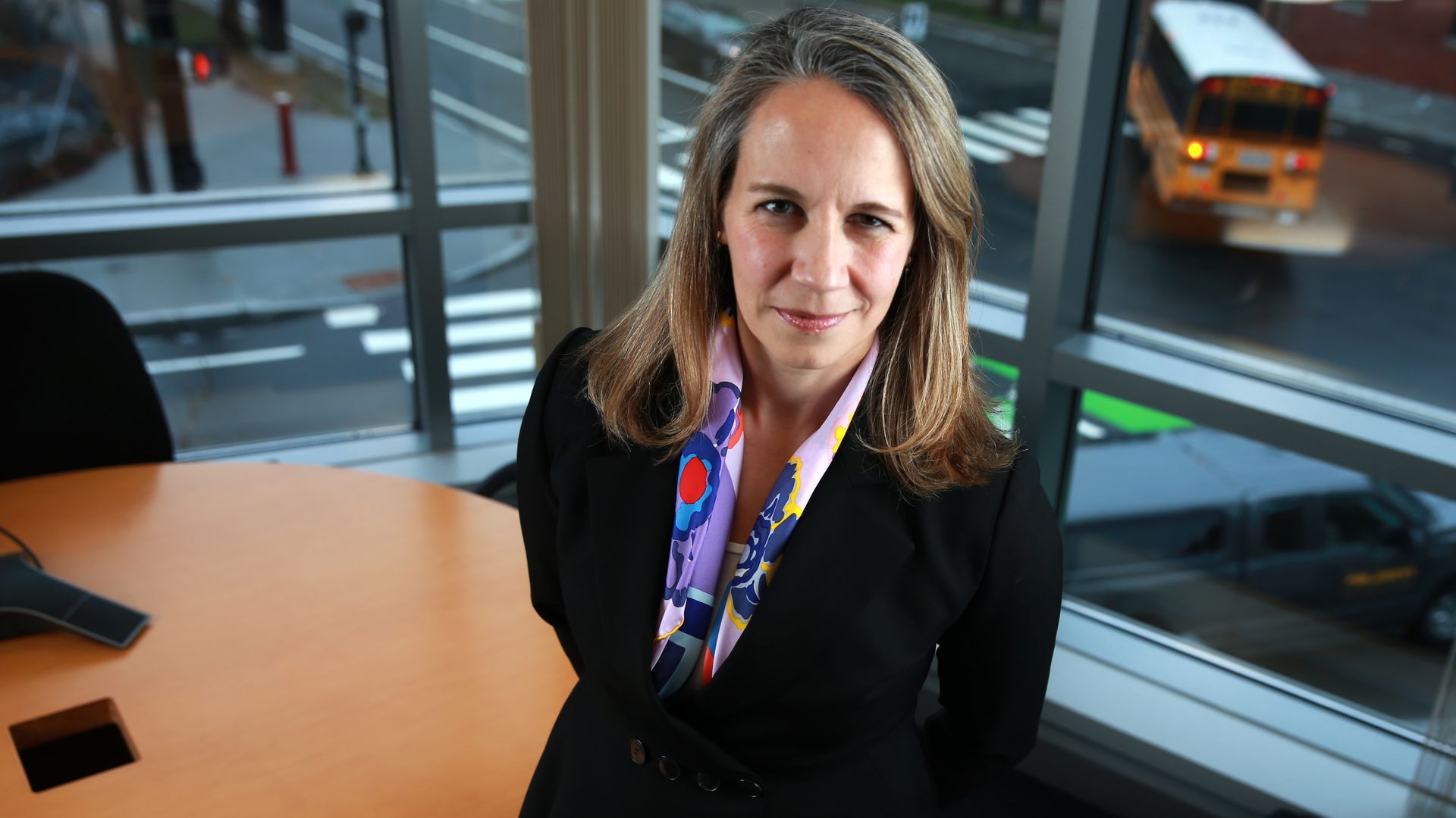 Editas Medicine Katrine Bosley stands in front of a table in an office.