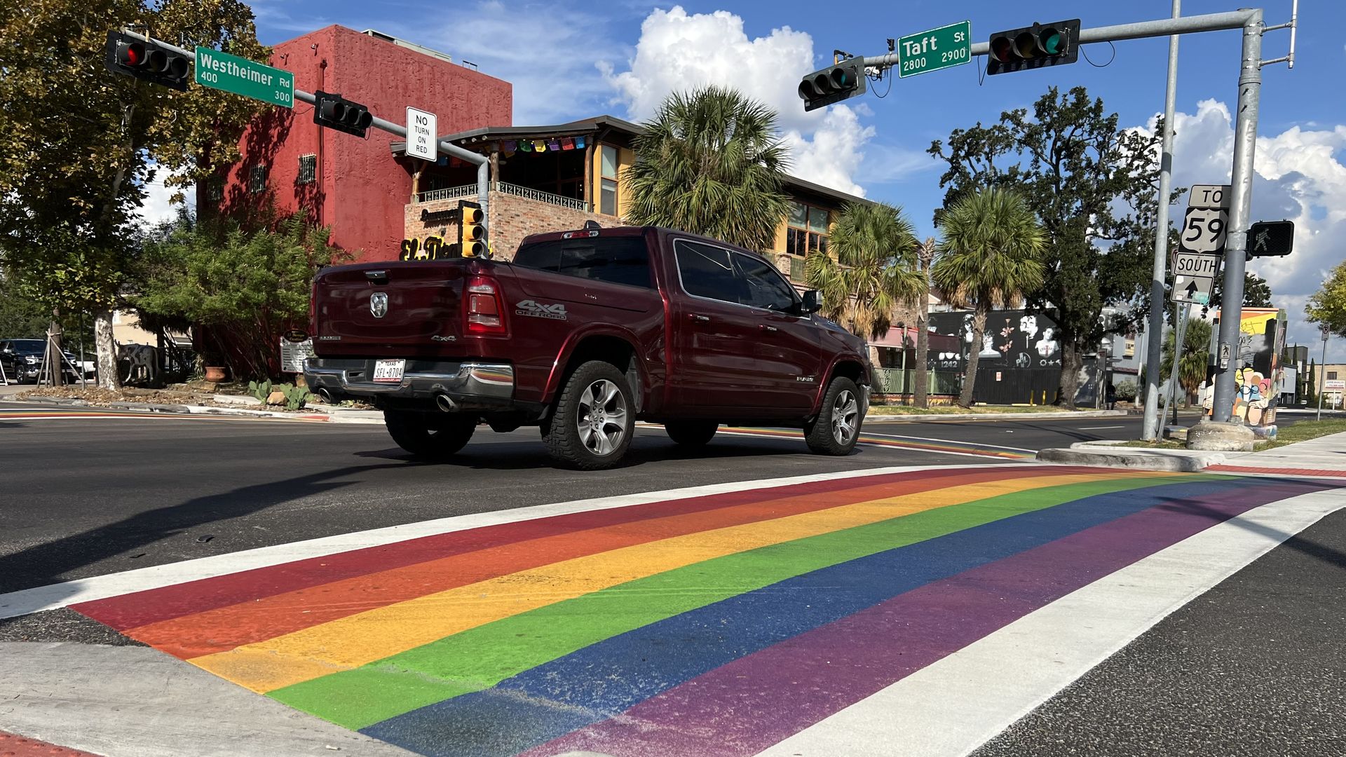 A maroon truck drives near rainbow crosswalk in Houston