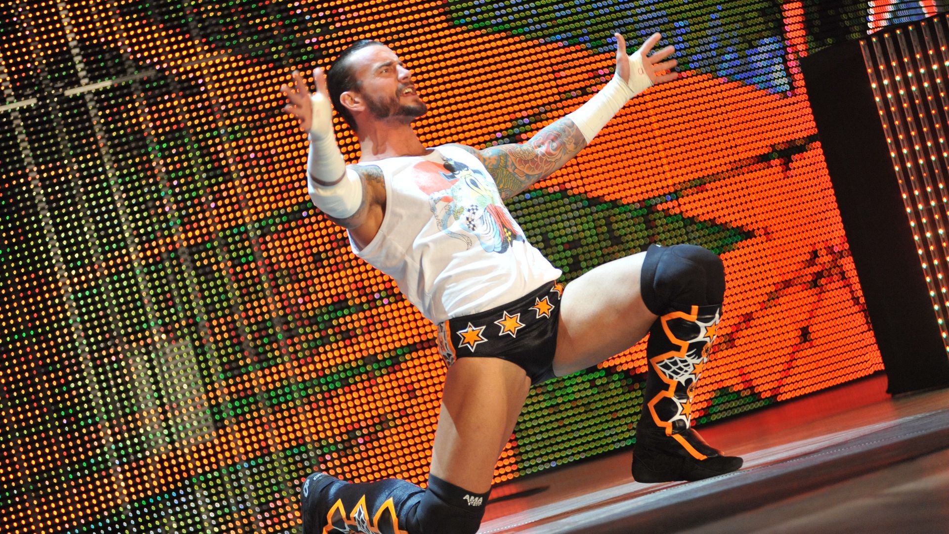 CM Punk poses at the top of the ramp at a wrestling event. 