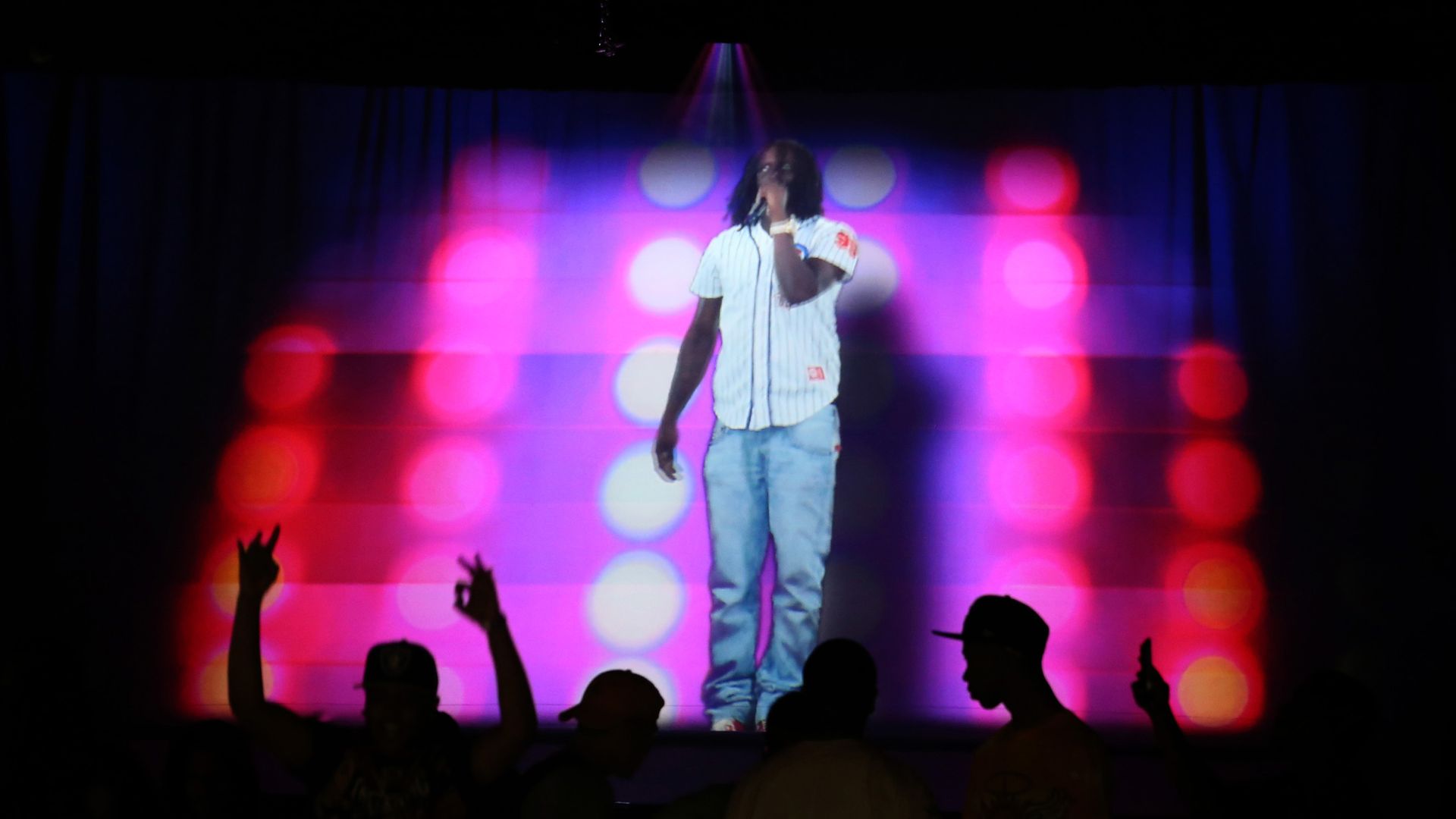 Photo of a hologram of a man performing on stage 