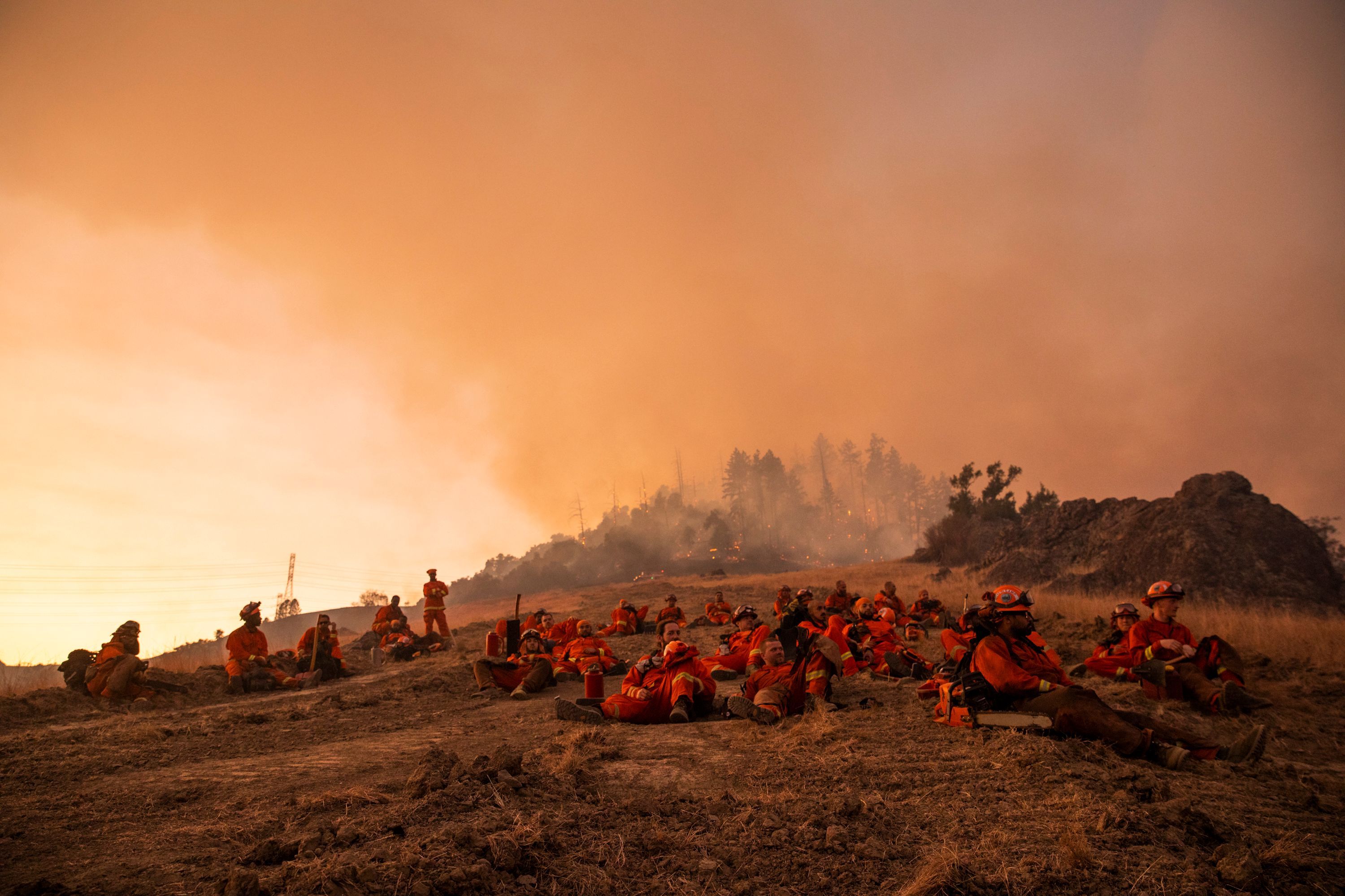 A crew of inmate firefighters takes a break during firefighting operations to battle the 2019 Kincade Fire in Healdsburg, California. 