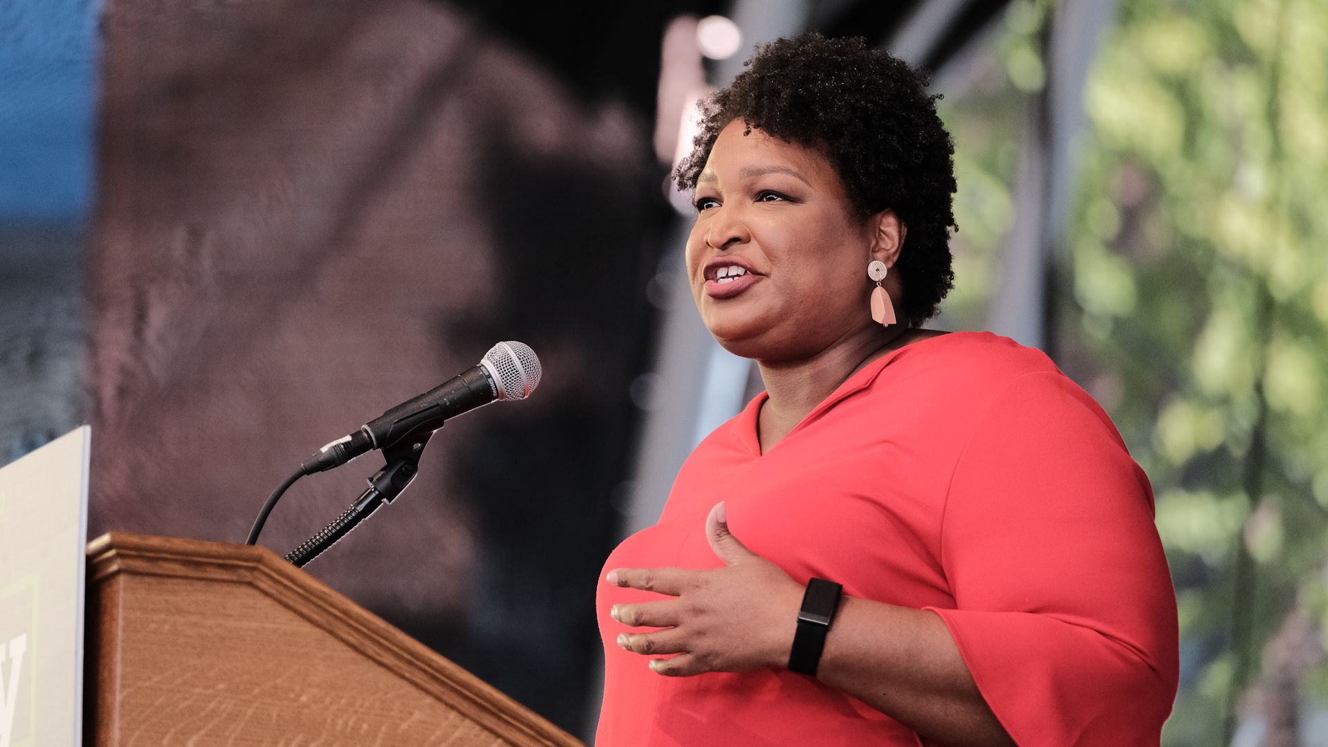 Photo of Stacey Abrams speaking from a podium on an outdoor stage
