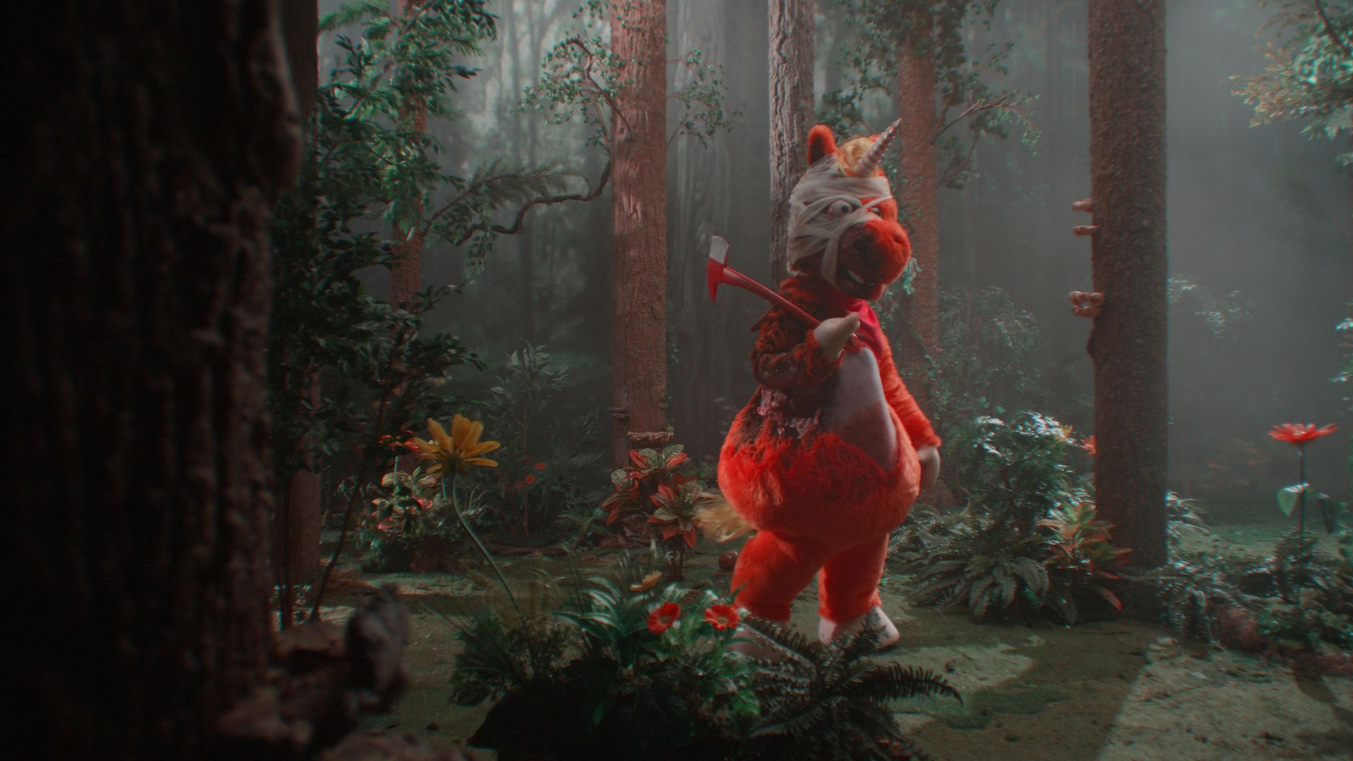 Orange unicorn mascot with a bandaged head holding a red axe stands in a misty forest surrounded by trees and colorful flowers.