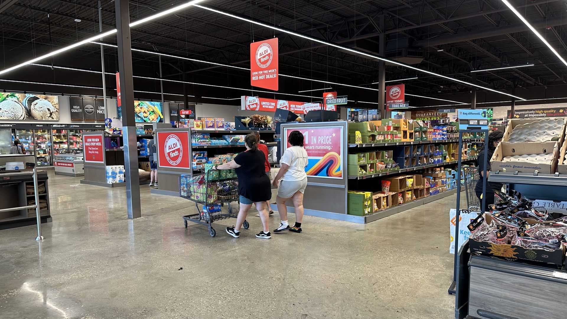 An interior view of Aldi. Shoppers pass between aisles.
