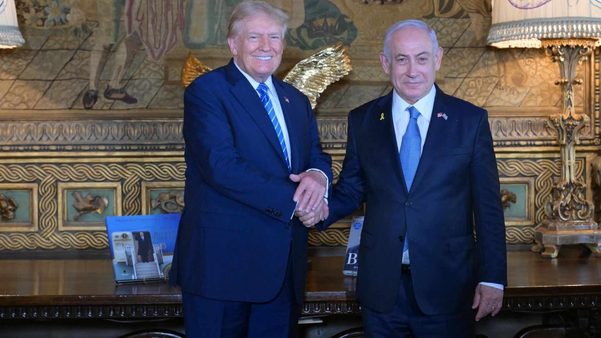 Former US President Donald Trump (L) shakes hands with Israeli Prime Minister Benjamin Netanyahu (R).