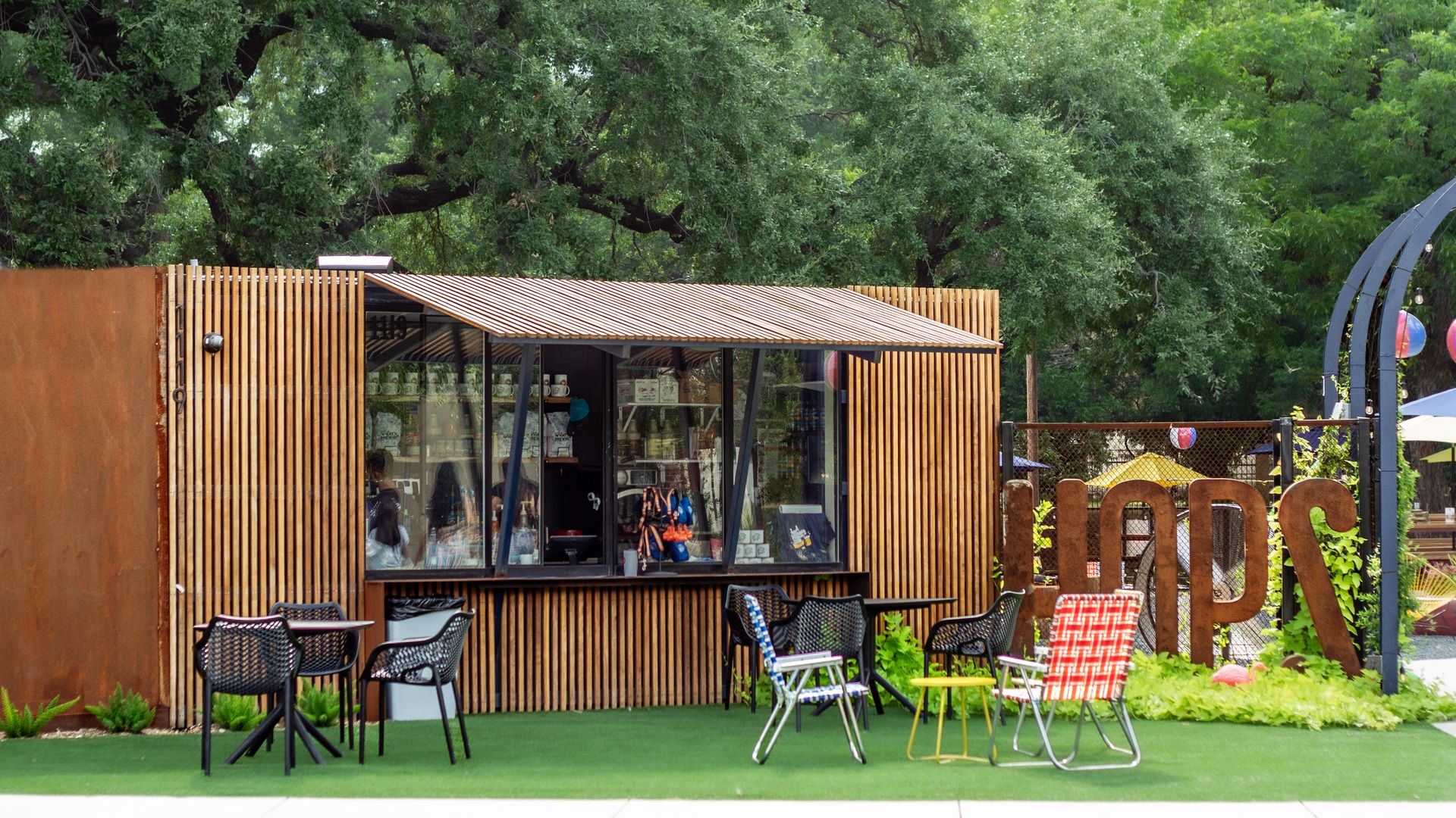 A small structure outfitted as a coffee shop sits on a patch of turf.