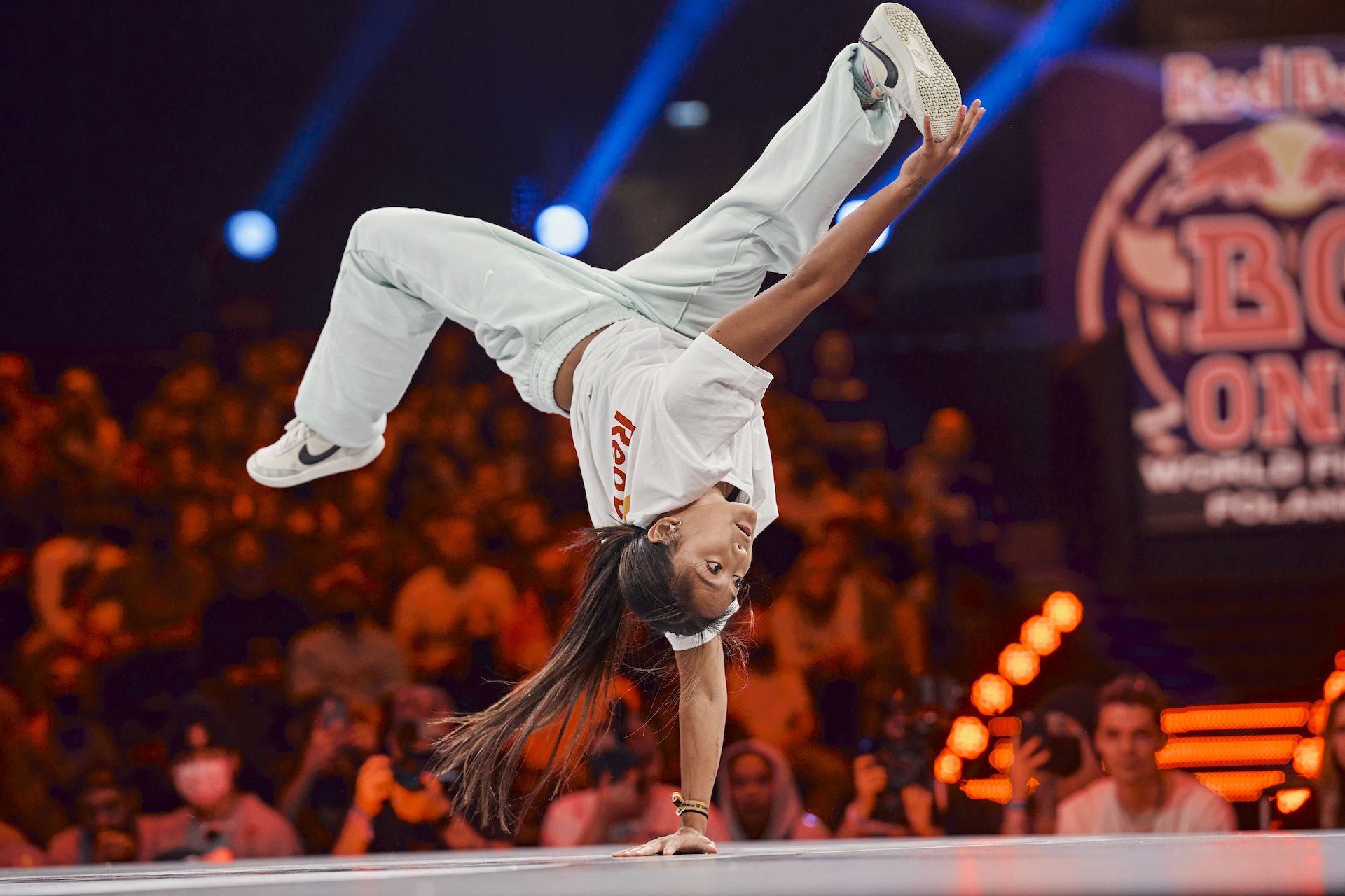 A girl breakdancer performing on stage.