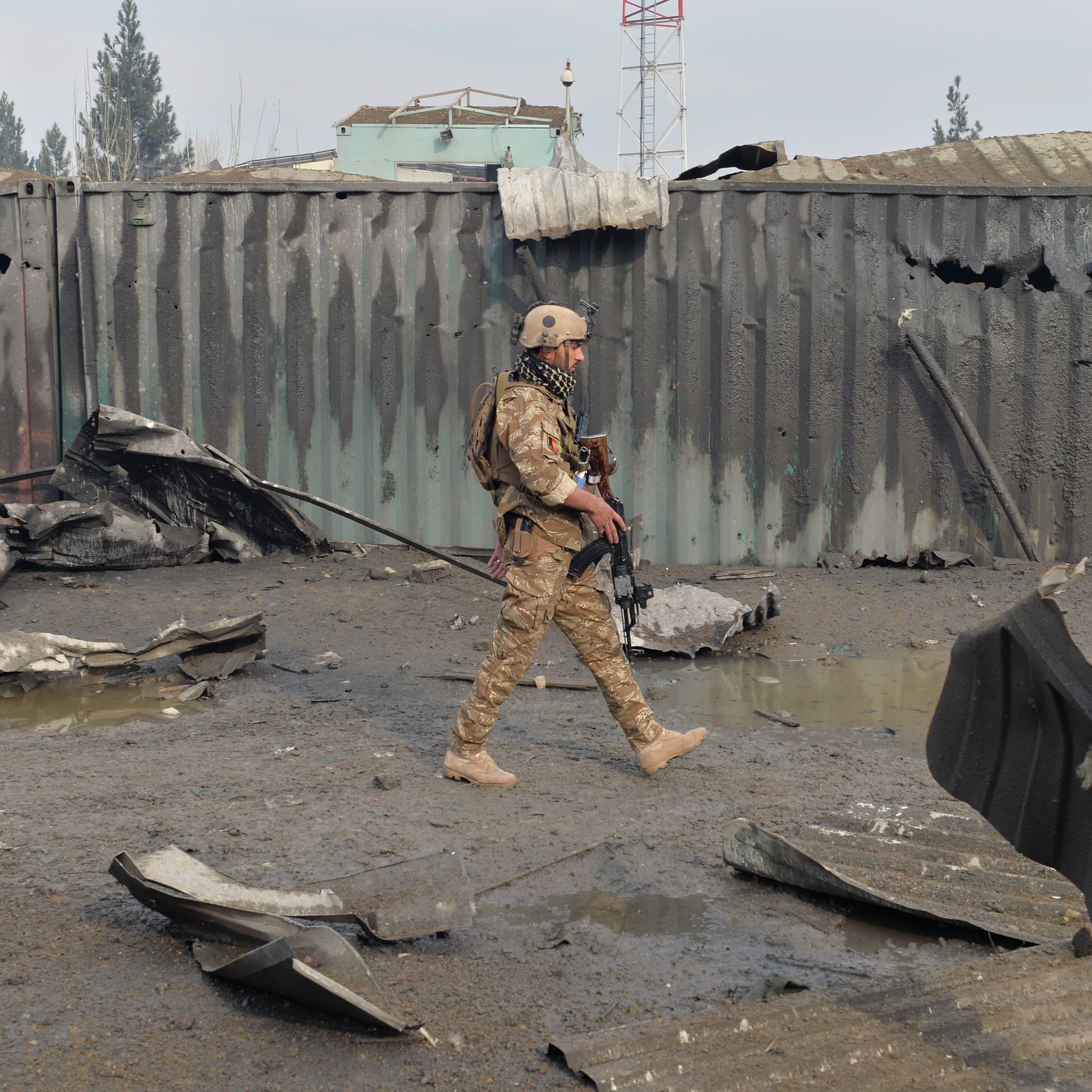 A member of the Afghan security forces walks at the site of a suicide bomb attack outside a British security firm's compound in Kabul, a day after the blast on November 29, 2018. 