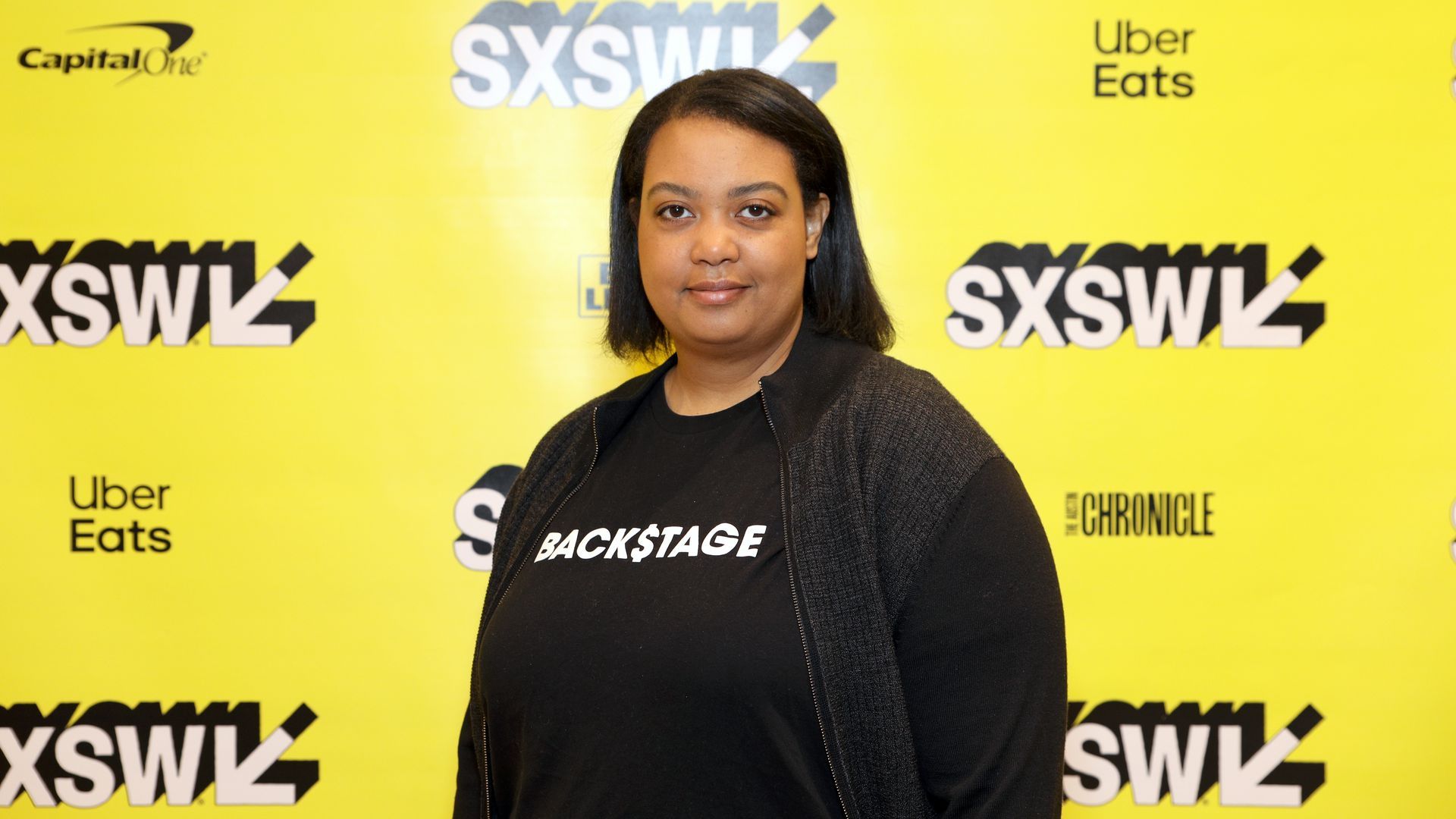 Arlan Hamilton wears a black shirt with the word "Backstage" on it, where the "S" is a dollar sign symbol.