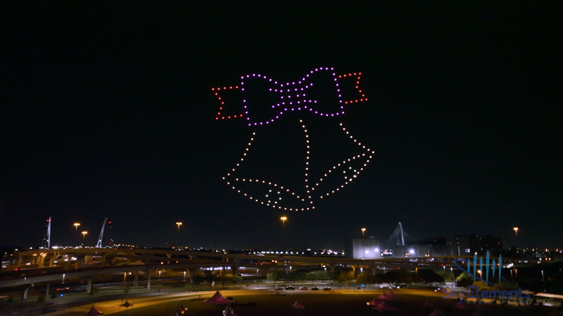 Colorful drones display two holiday bells during a drone show. 