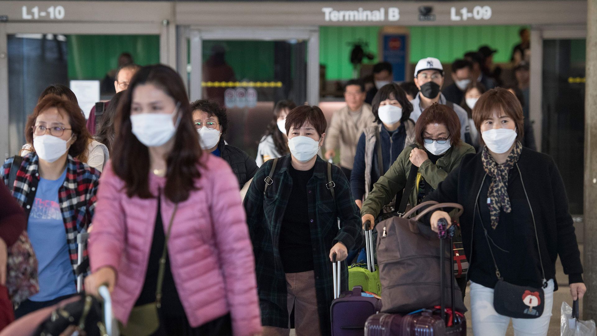 Passengers arriving at LAX wear protective masks to guard against coronavirus.