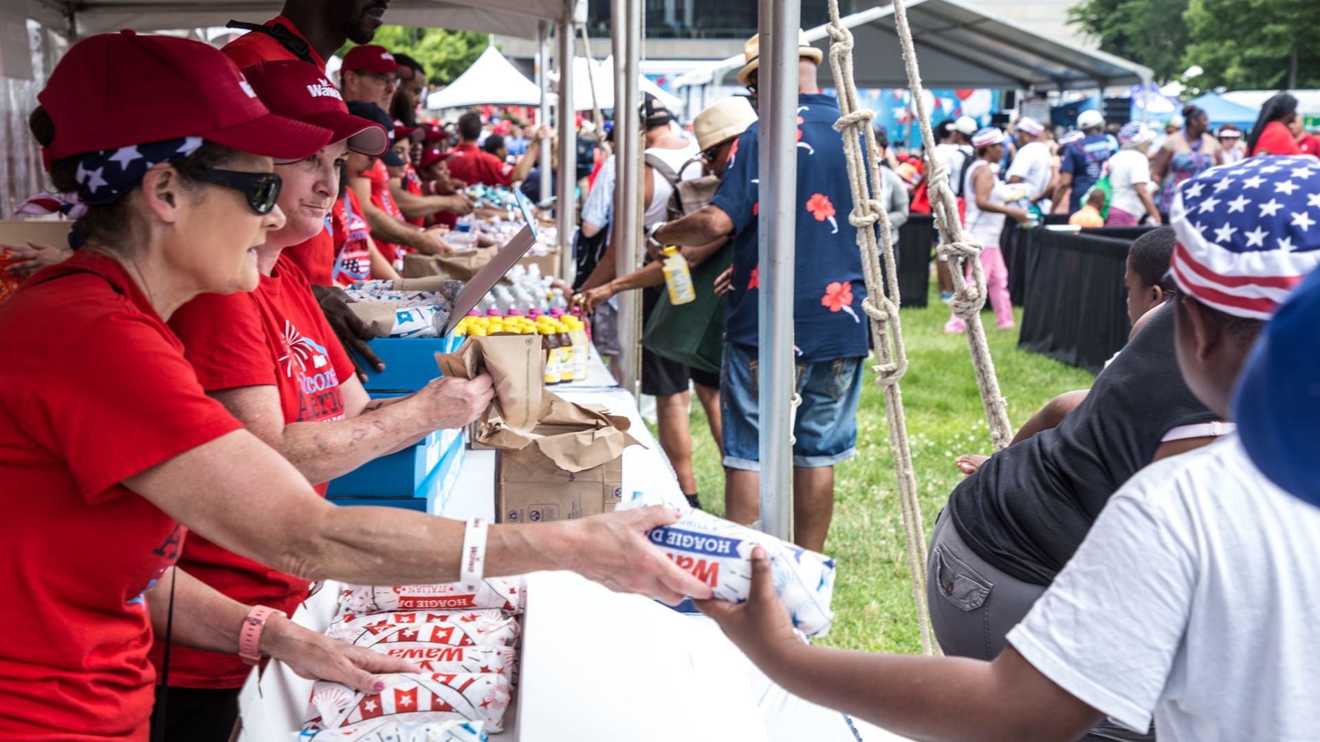 A person handing out hoagies