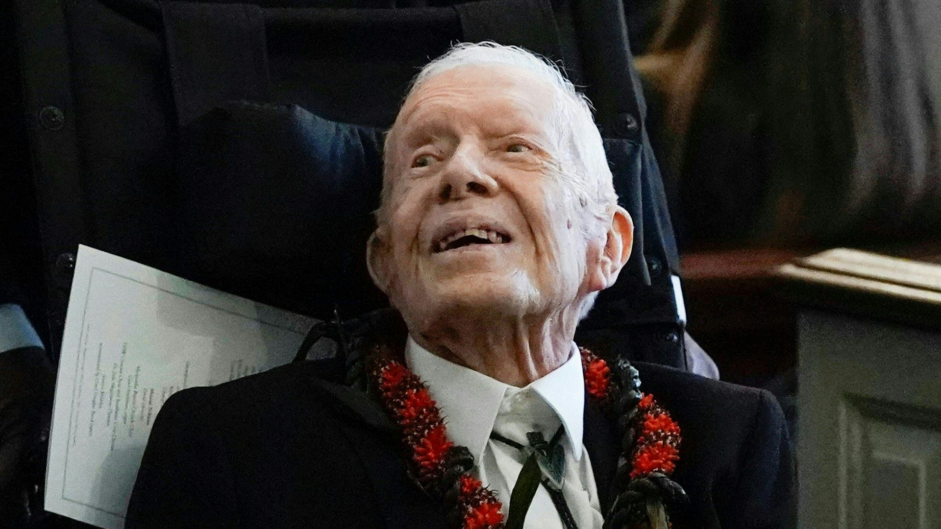 Jimmy Carter, seated, looks up
