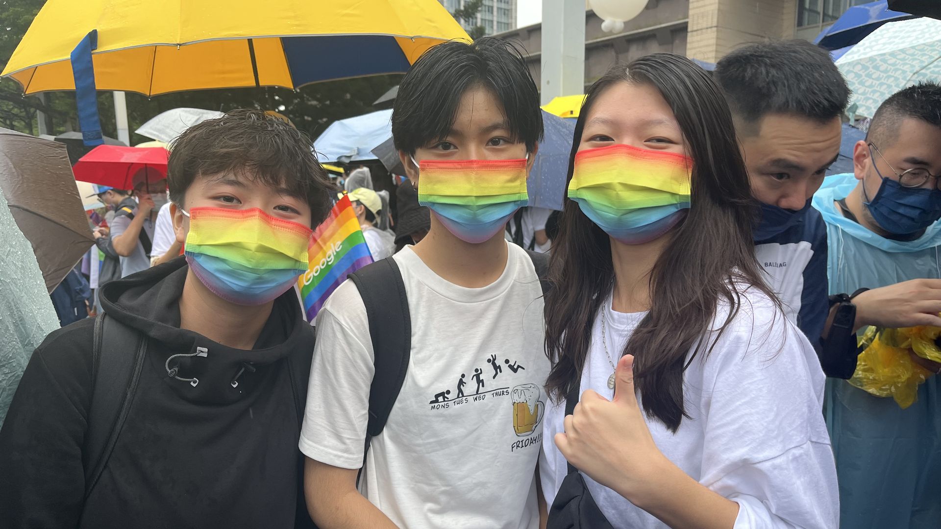 Three participants wear rainbow face masks at the Taipei Pride March on October 29, 2022.