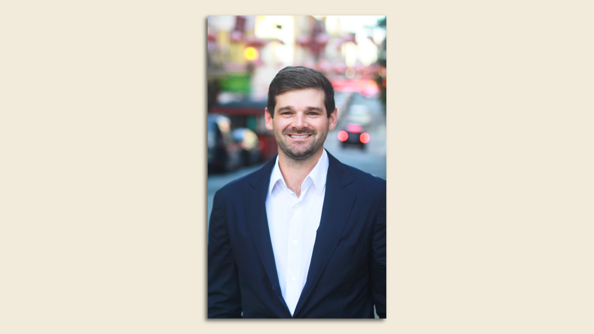Photo of Matt Susk in a dark navy suit standing in a Chinatown street