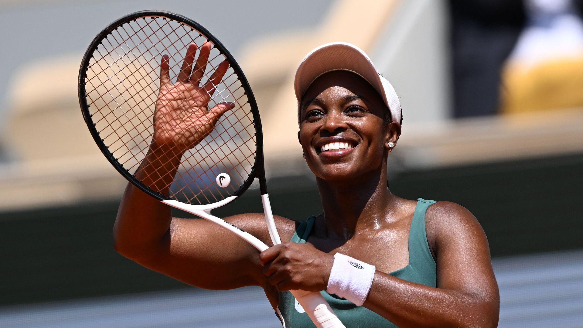 Tennis player Sloane Stephens gestures to the crowd with her racket. 