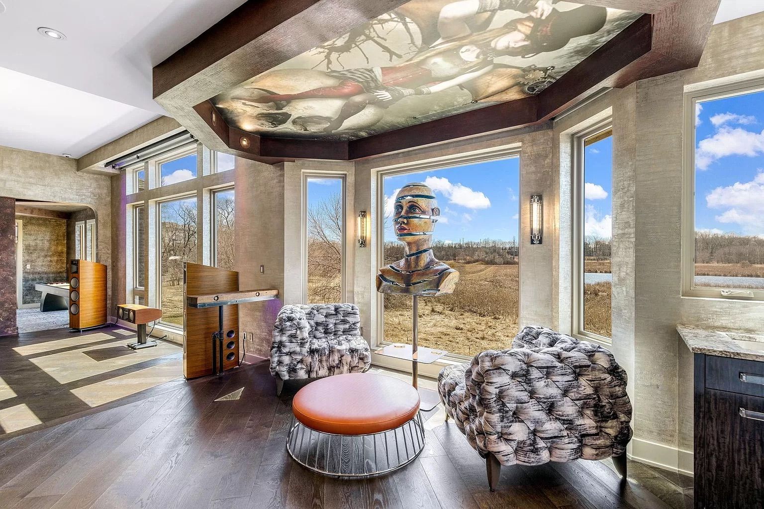 A section of a room with two black and white chairs and a sculpture of a head.