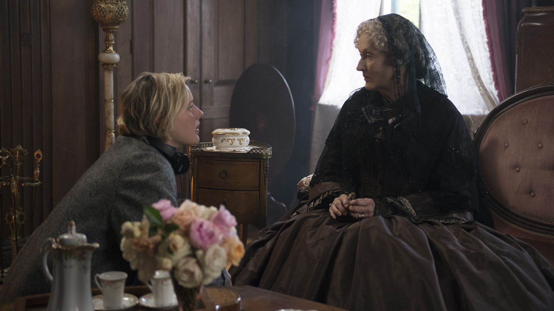In this image, Meryl Streep sits in period Victorian dress while speaking with director Greta Gerwig.