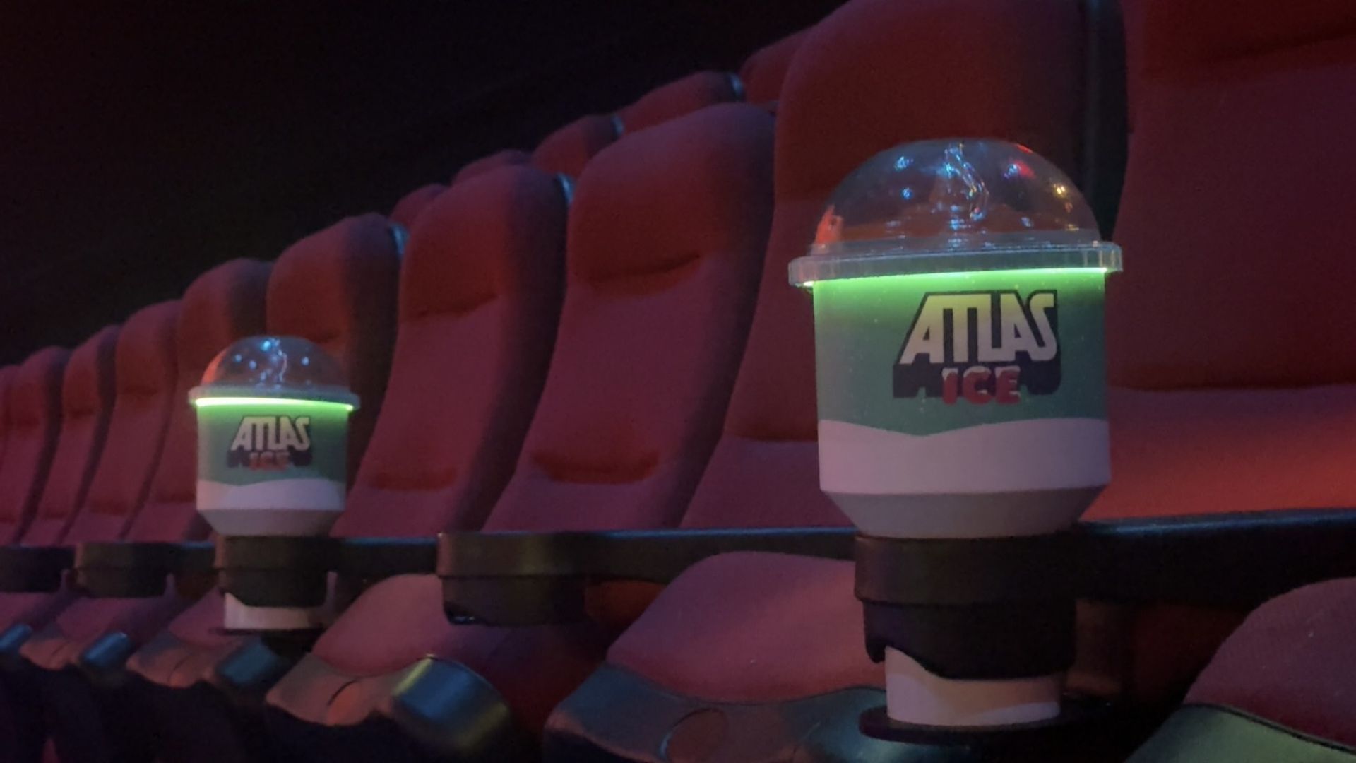 Red cushioned theater seats with glowing green and white 