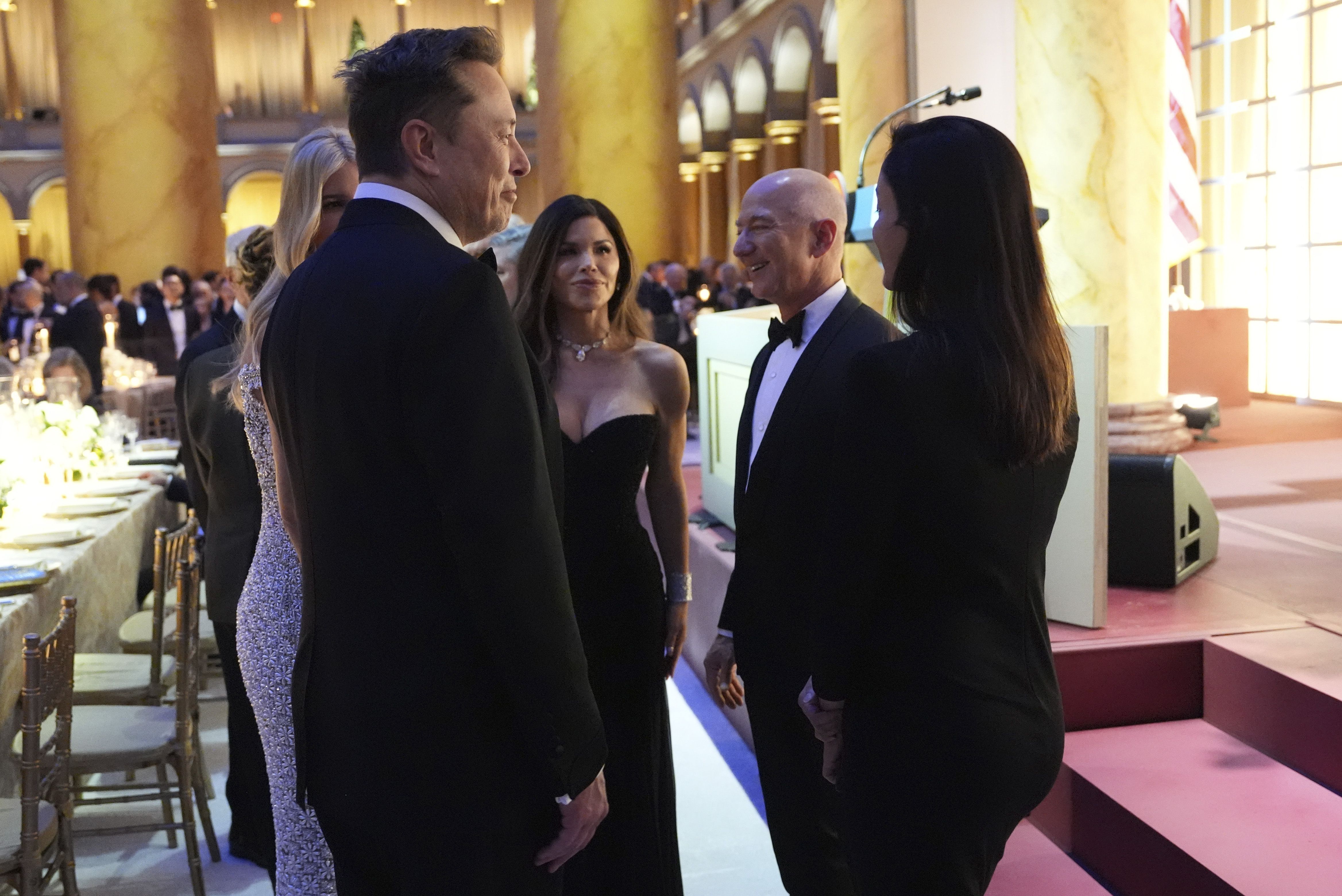 Elon Musk, front left, talks with Ivanka Trump, from left, Lauren Sánchez, Jeff Bezos and Shivon Zillis before President-elect Donald Trump speaks at a dinner at the National Building Museum, Sunday, Jan. 19, 2025, in Washington. (AP Photo/Evan Vucci)
