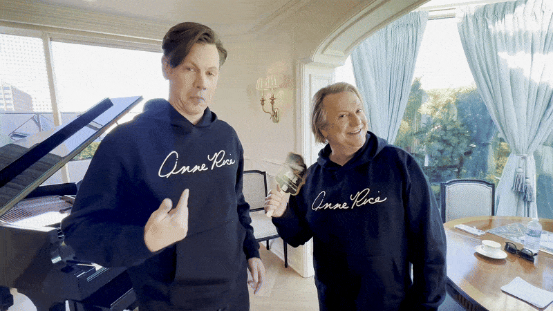 Image shows two men pointing to Anne Rice sweatshirts.