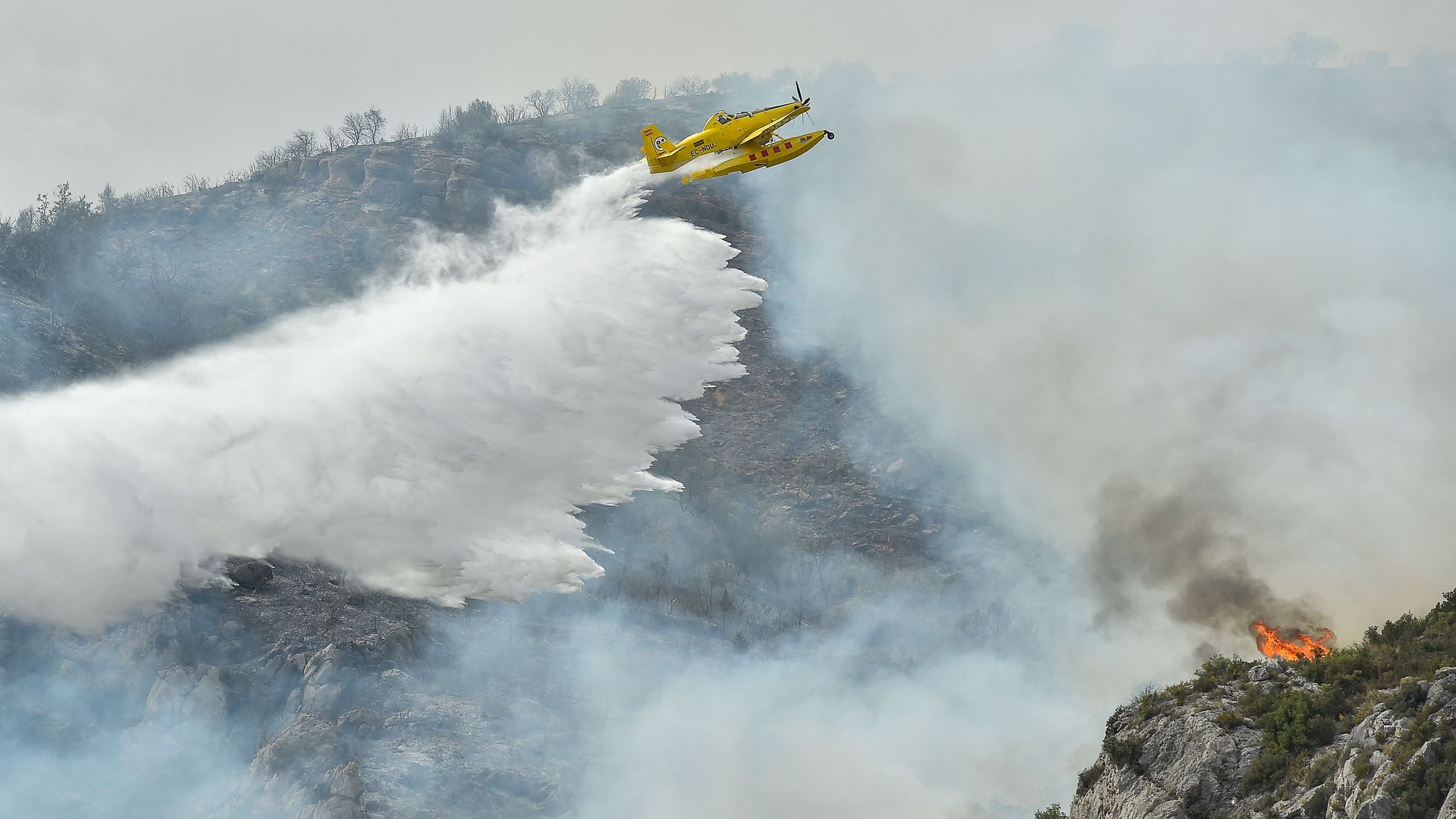 A firefighting plane drops water on a blaze near Artesa de Segre, in Catalonia, Spain, on June 16.