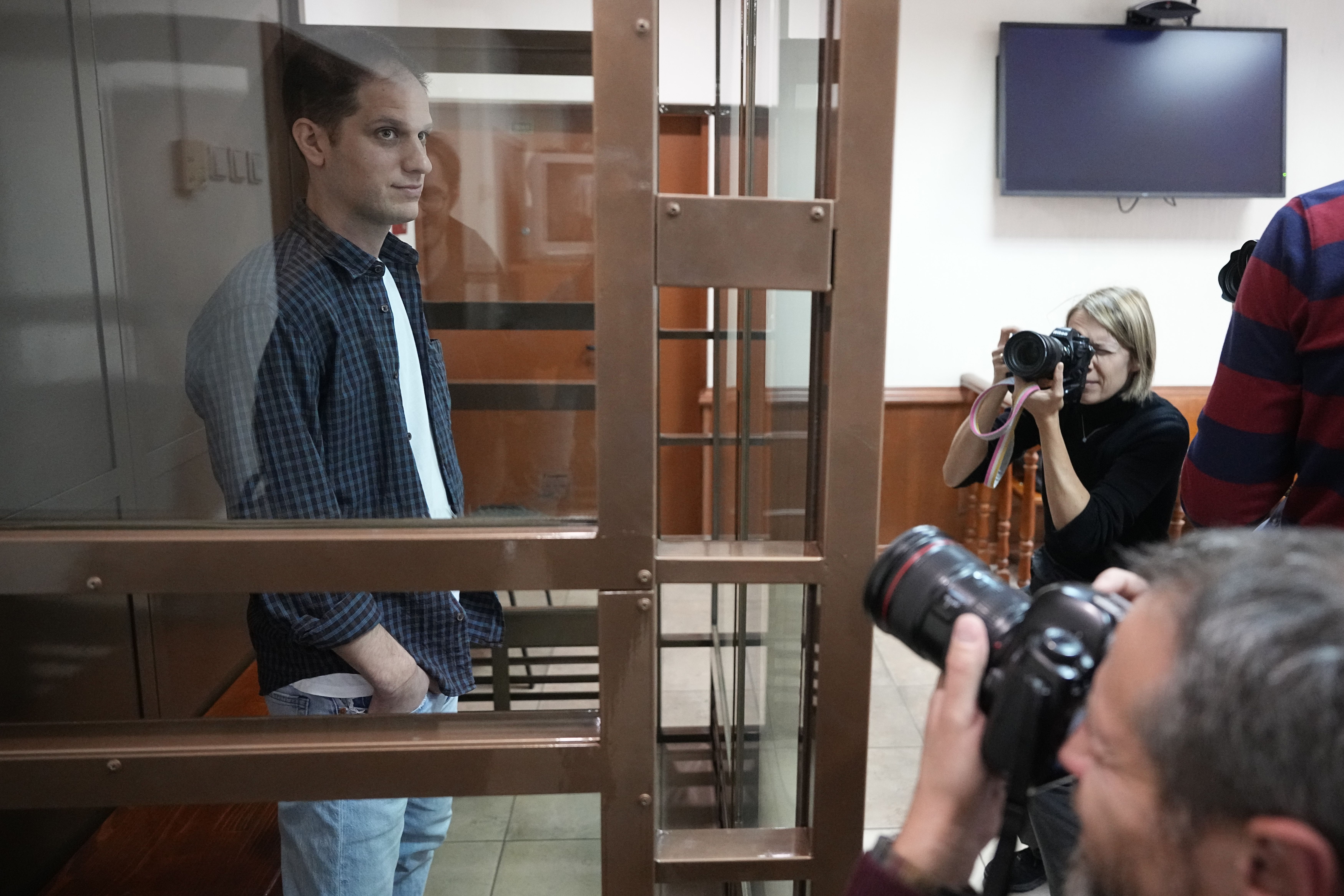 Wall Street Journal reporter Evan Gershkovich stands in a glass cage in a Moscow courtroom in October.