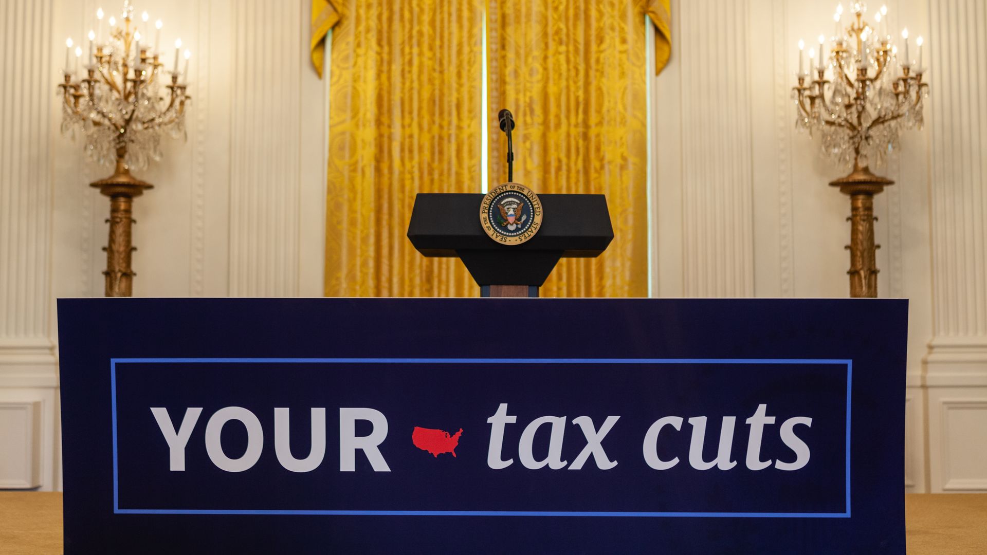 Lecturn behind a sign that says "YOUR tax cuts"