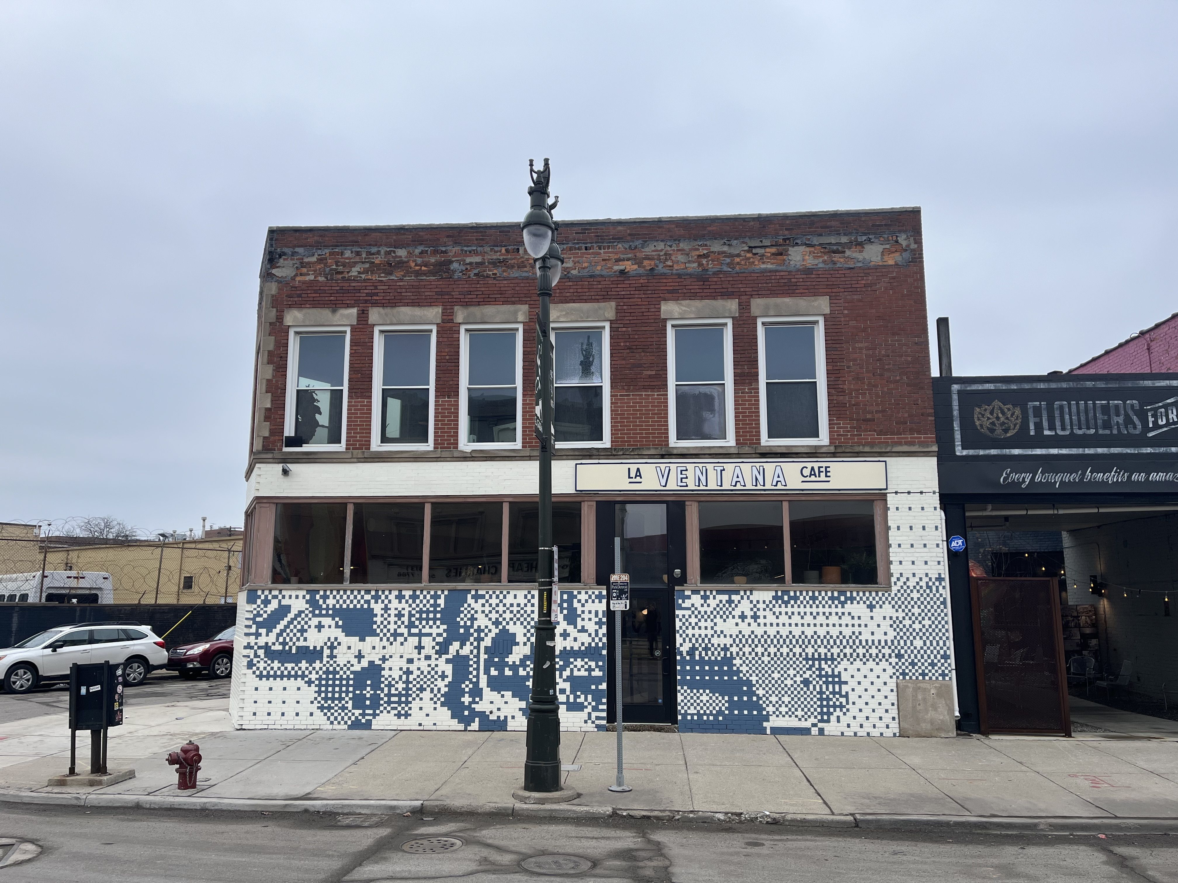 The cafe's facade is brick and blue and white tile.