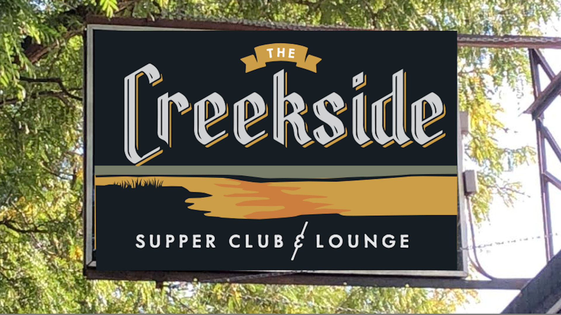 A sign with Creekside Supper Club in white letters above orange 