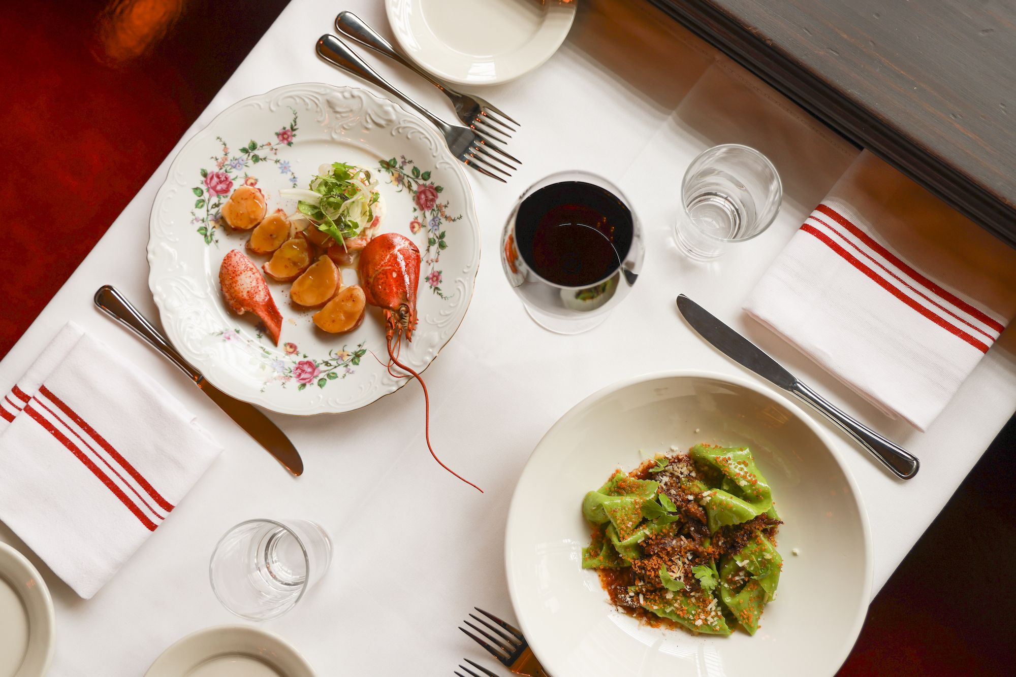 A table set with a plate of lobster medallions and pasta