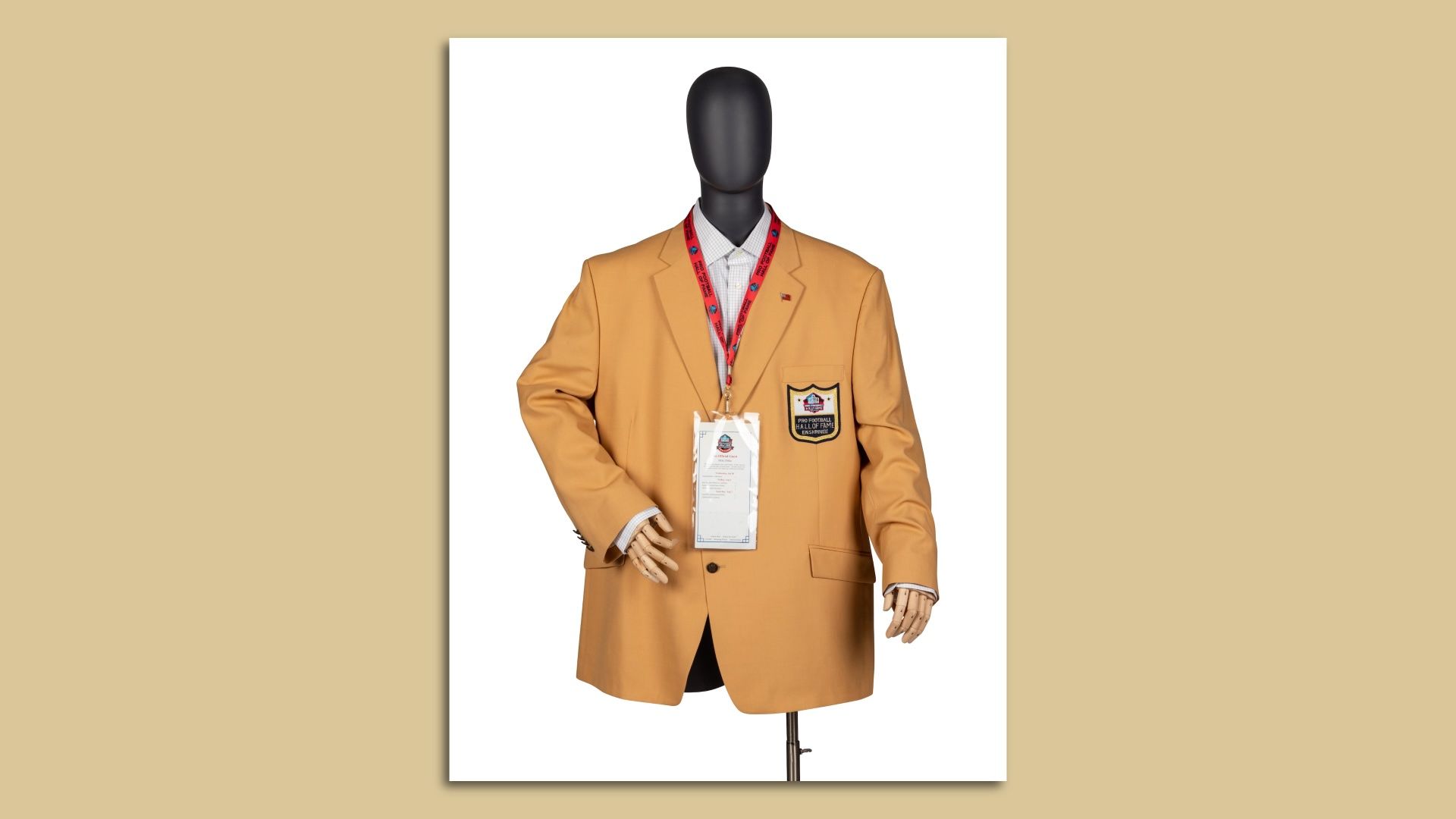 Faceless mannequin wearing a mustard colored blazer.