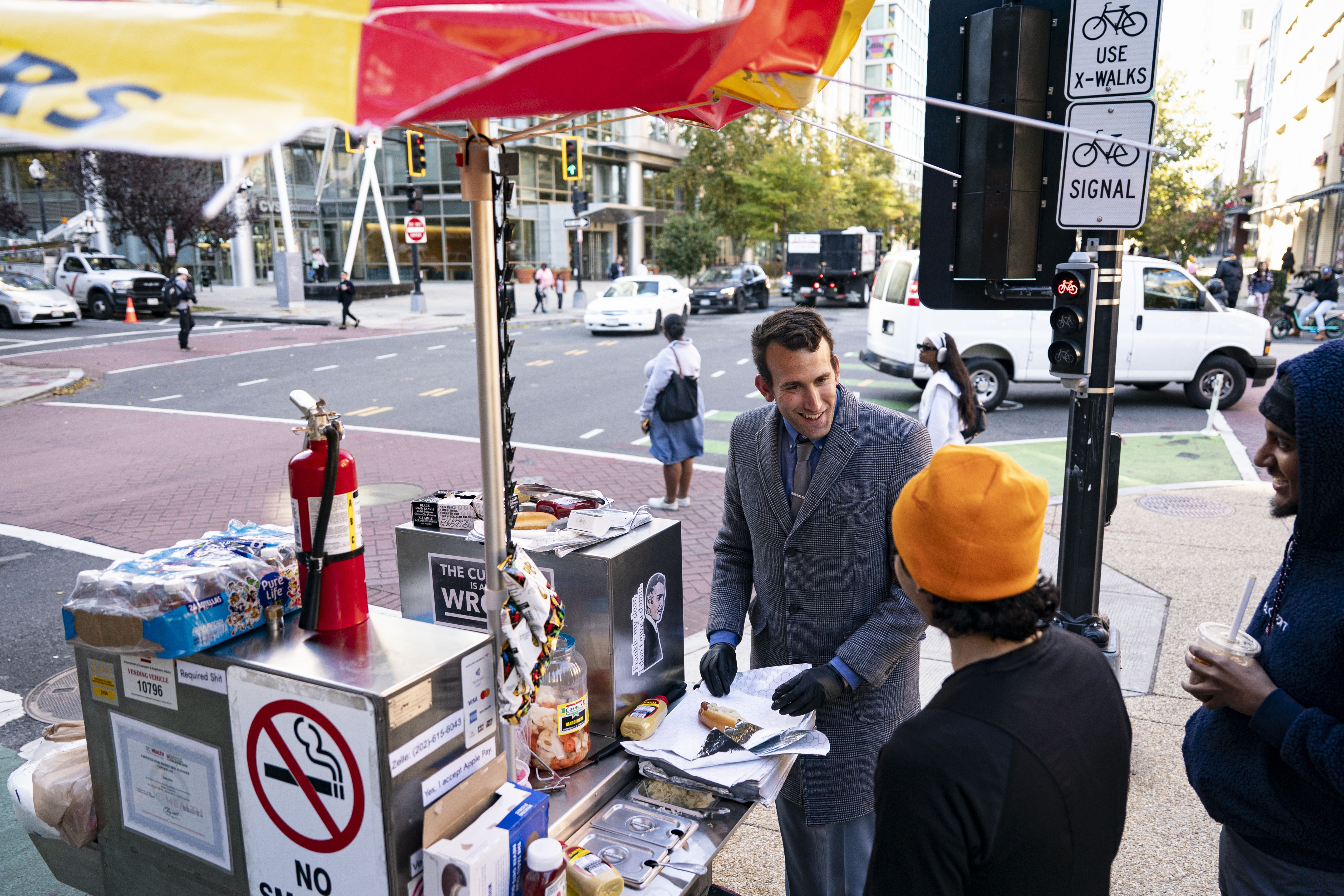 Isaac Stein, a lawyer at the Internal Revenue Service (IRS) who is currently furloughed due to the U.S. government shutdown, sells hotdogs at his hotdog stand, Shysters Dogs, in the NOMA neighborhood on October 31, 2025 in Washington, DC.