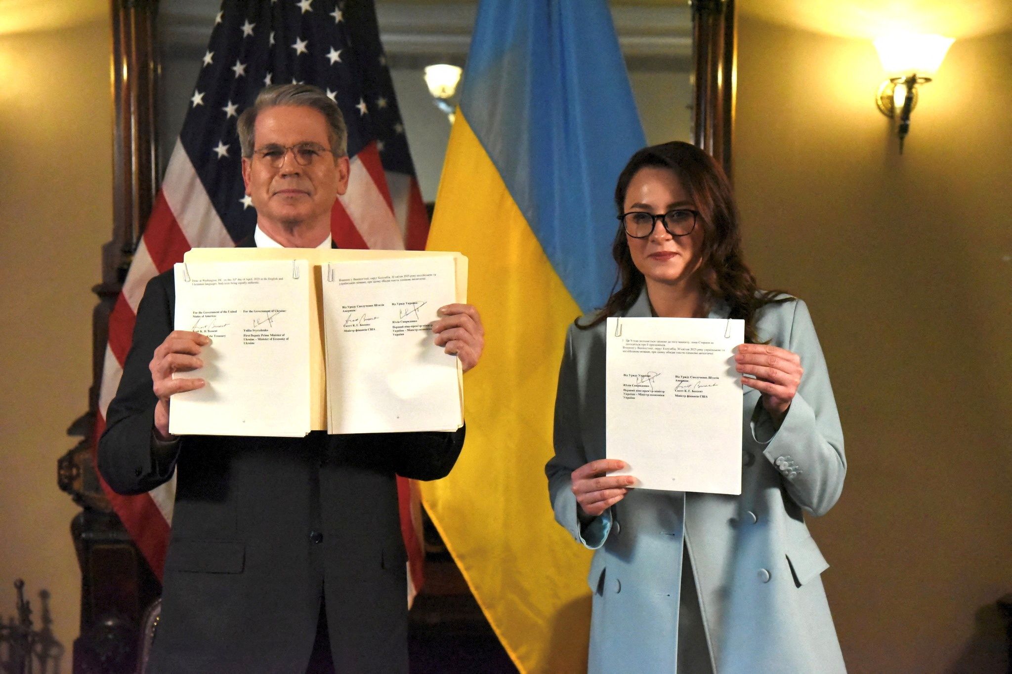 Treasury Secretary Scott Bessent and Ukrainian Economic Minister Yulia Svyrydenko hold up a signed the Ukrainian mineral profits deal.