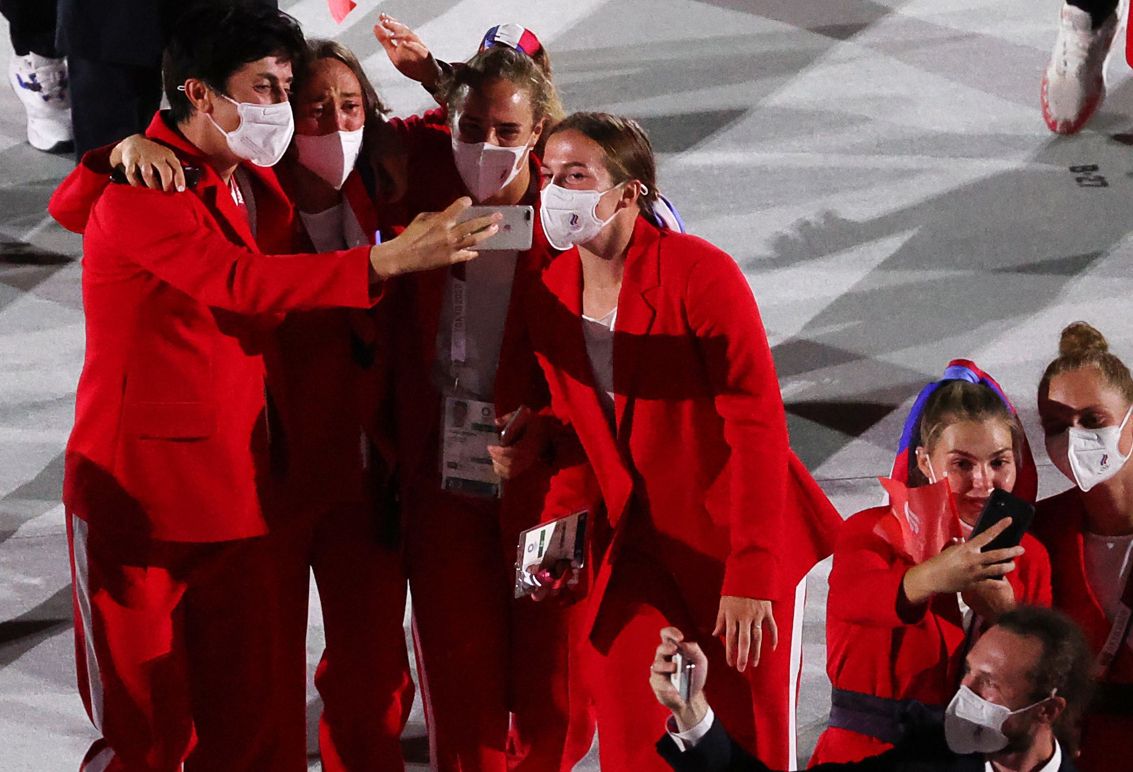 Picture of Russian athletes wearing red suits during the opening ceremony taking a selfie