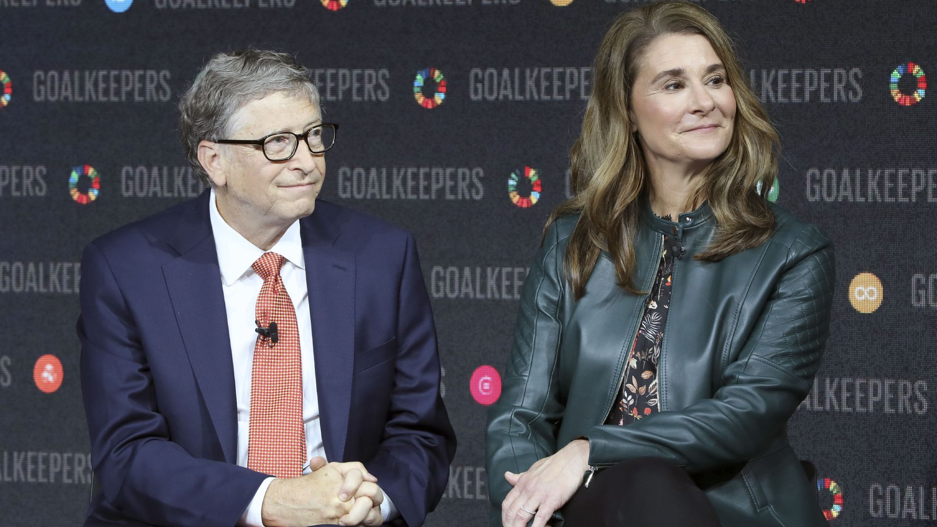 Bill and Melinda Gates sit next to each other with a wall that says "Goalkeepers" several times