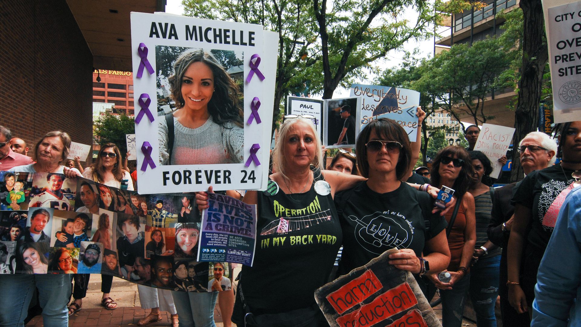 Advocates for a safe injection site hold signs honoring loved ones in Philadelphia.
