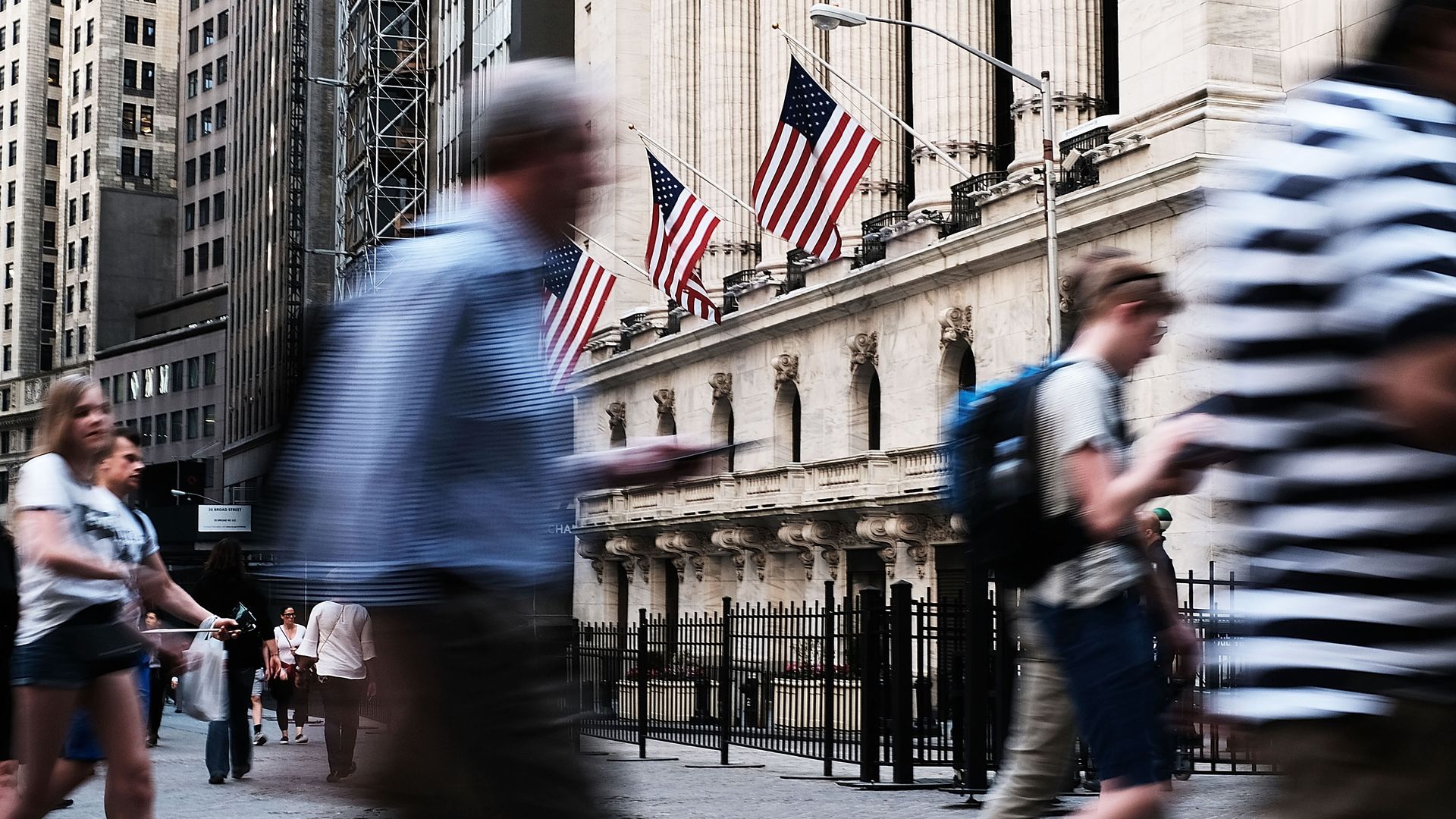 People walk outside of the New York Stock Exchange.