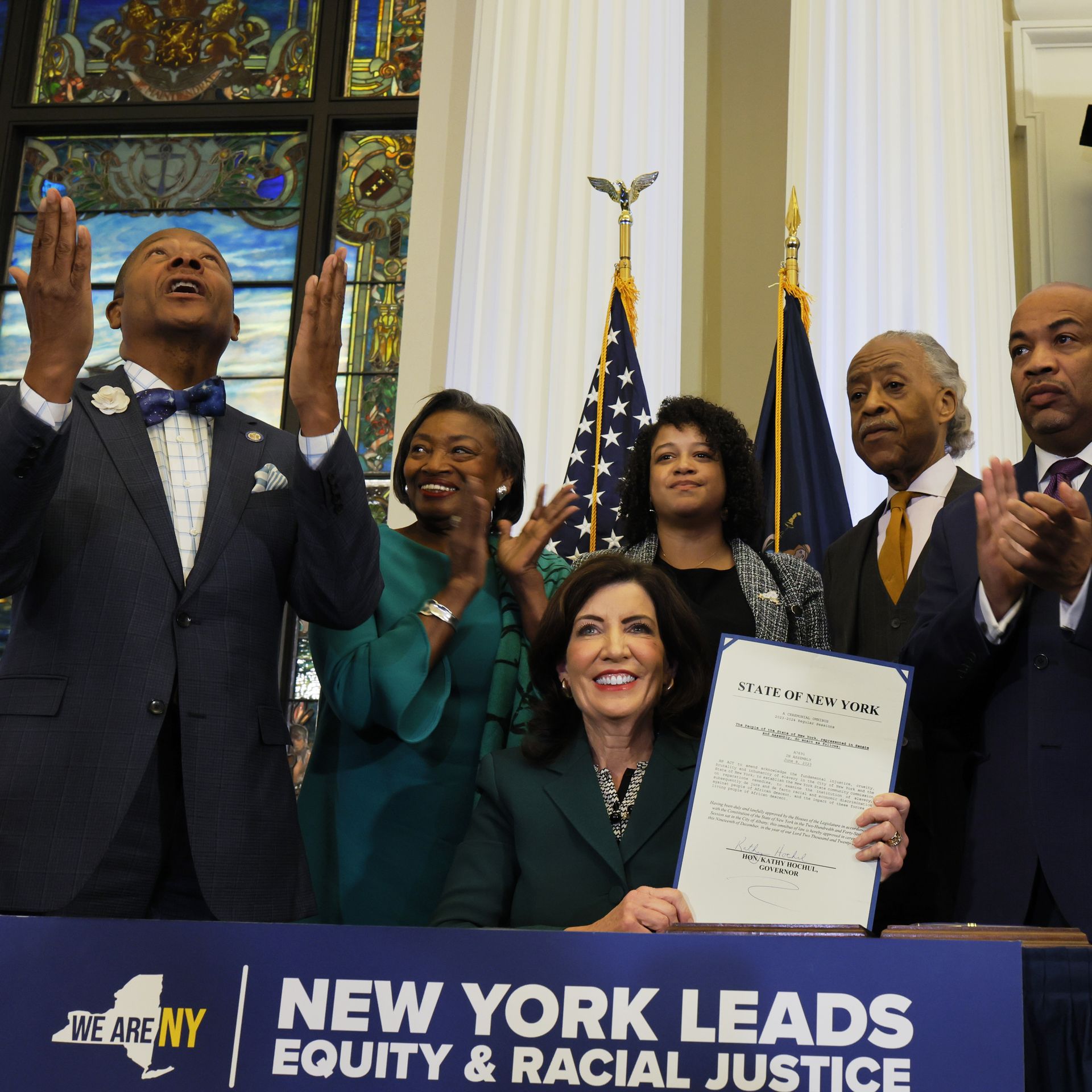  New York Gov. Kathy Hochul holds up signed legislation creating a commission for the study of reparations in New York on December 19, 2023.
