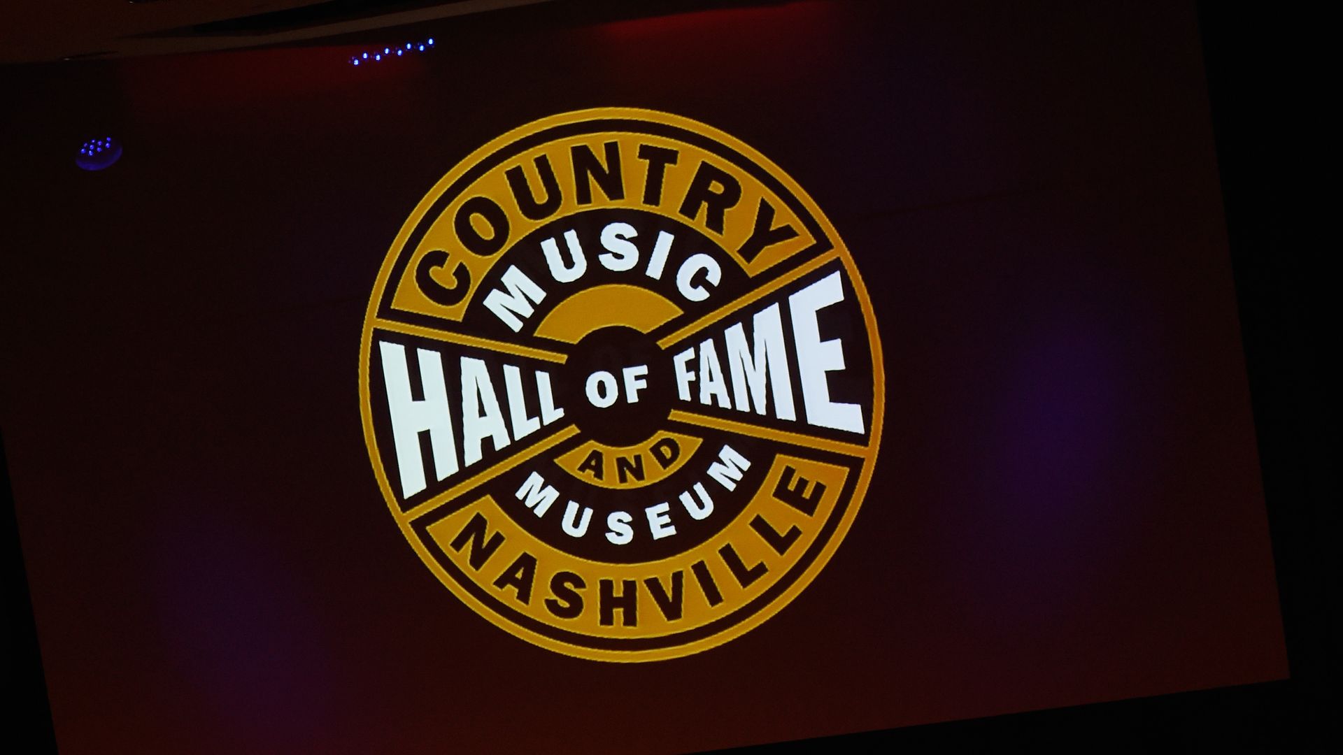 The Country Music Hall of Fame logo projected on a big screen.