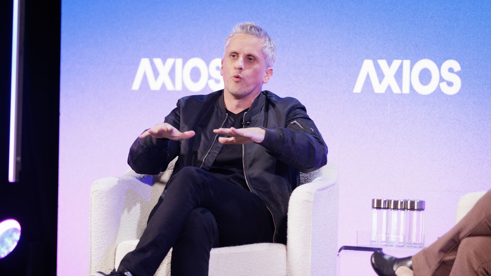 Levie, wearing a full black outfit and jacket on stage 