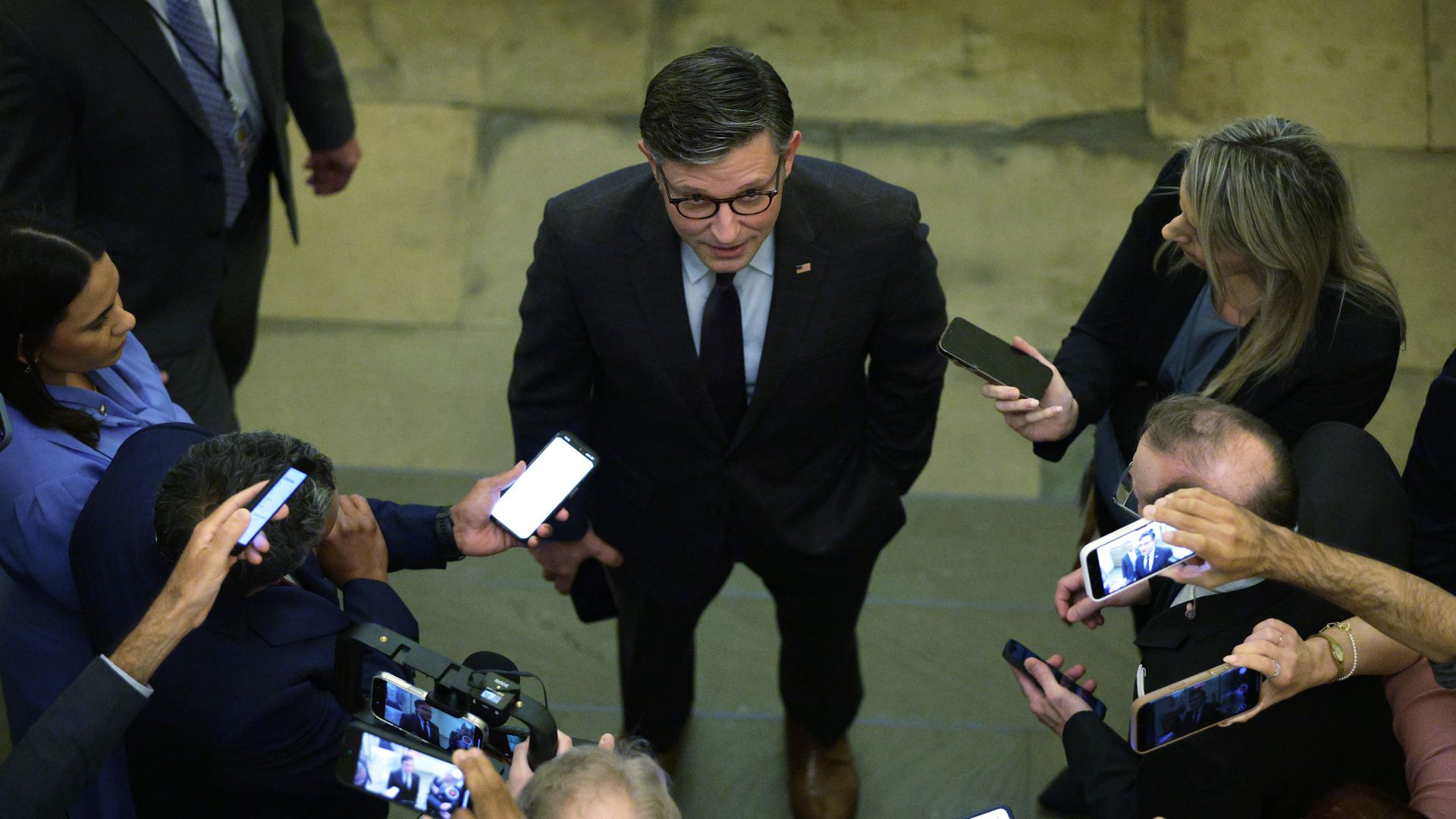 Mike Johnson, talking and being surrounded by reporters