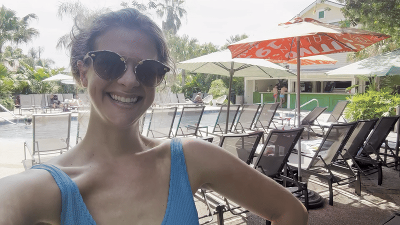 A woman smiles into the camera and shifts her shoulder.