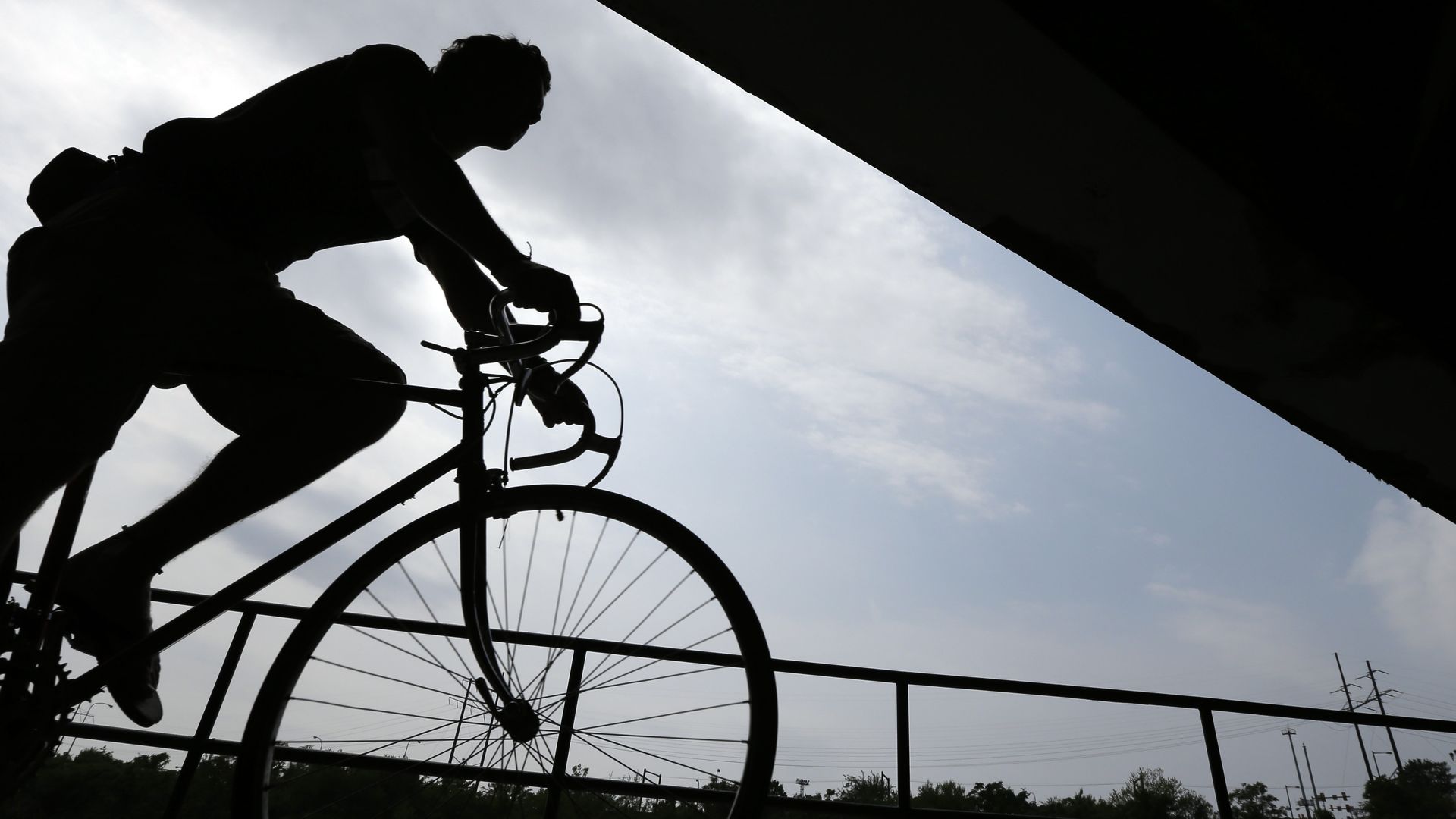 A photo of a cyclist on the Schuylkill River Trail passing beneath an overpass.