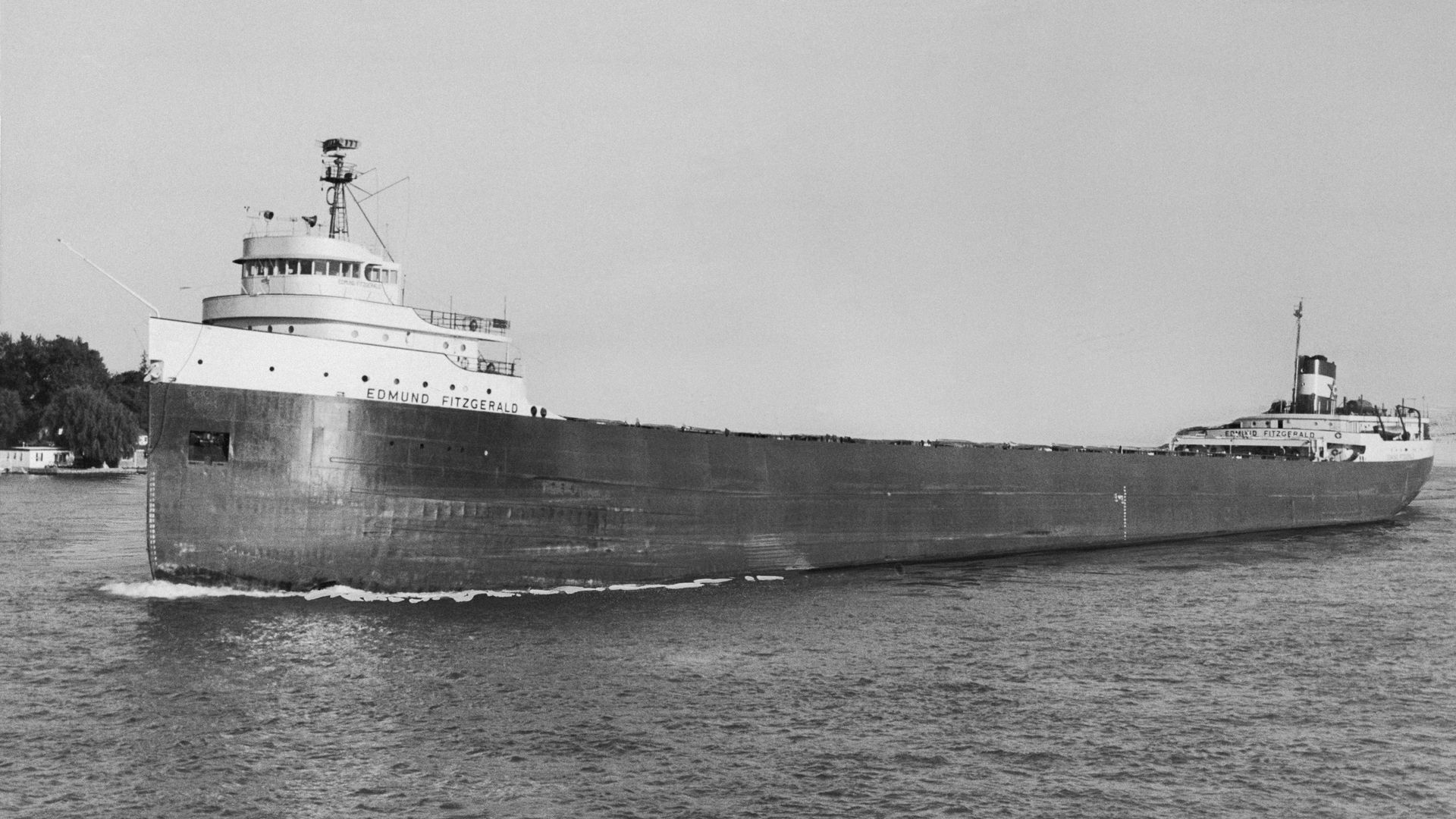 A black and white photo of the Edmund Fitzgerald in the water, with the pilot house in the front. 