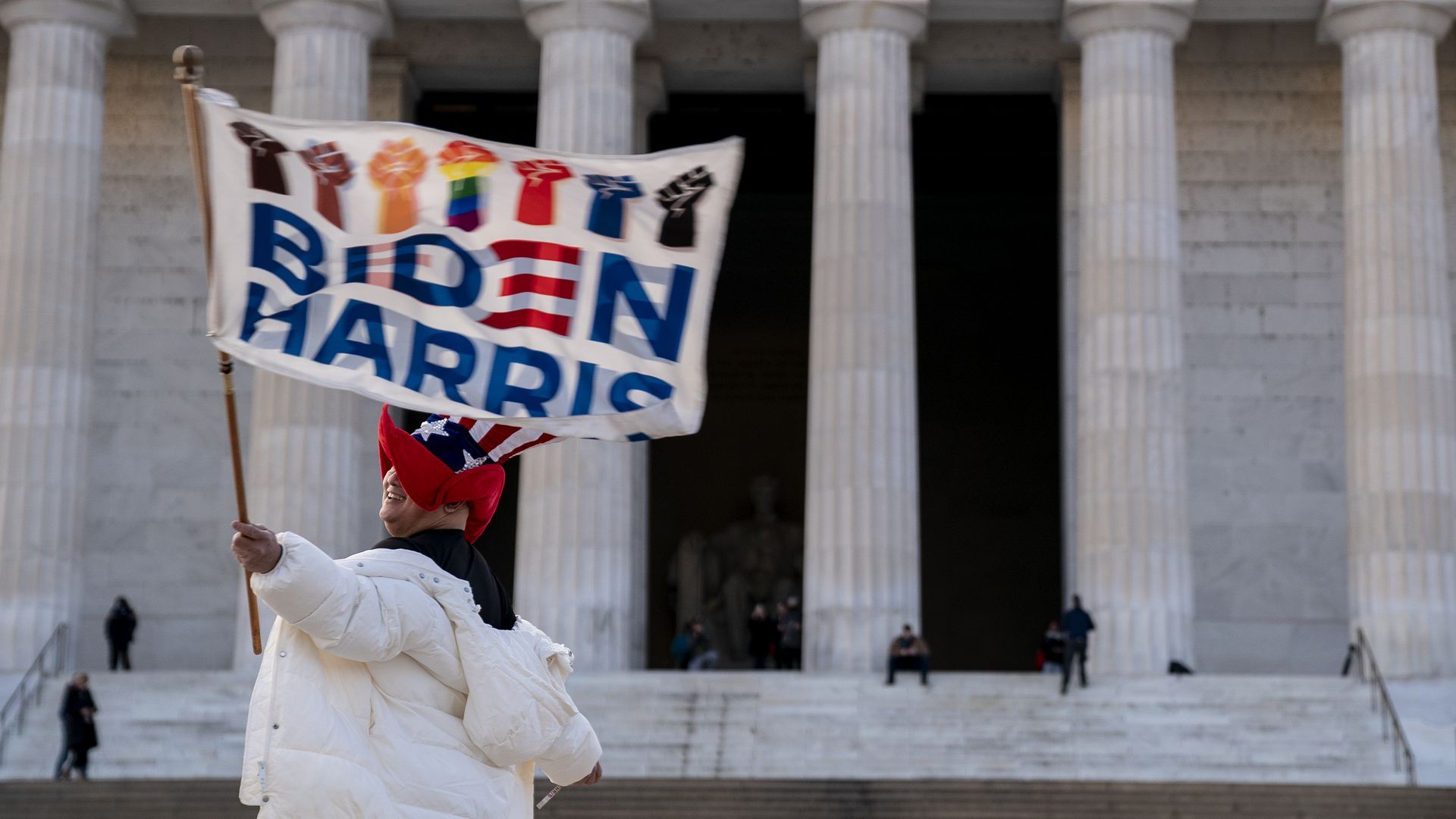 Kyriaki Chris of Virginia waves a Biden-Harris flag near the Lincoln Memorial.
