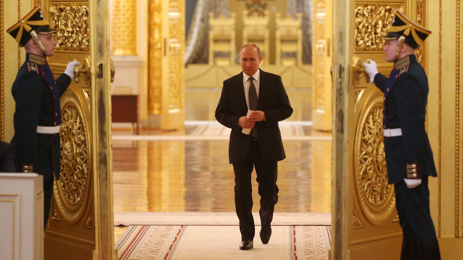 Vladimir Putin walks through golden doors at the Grand Kremlin Palace.