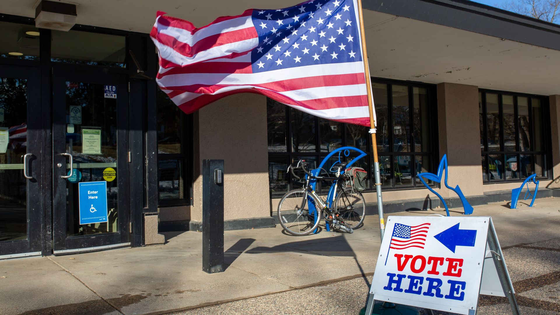 Vote here sign and a flag.