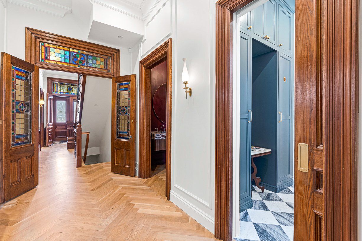 A real estate photo showing pocket doors and stained glass at the entrance and entry-level hallway of 31 Monument Square. 