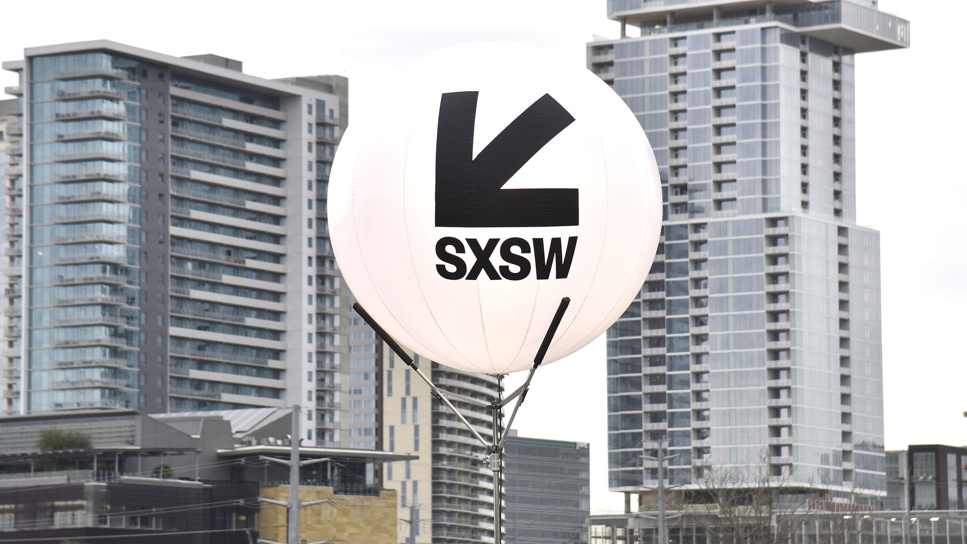 A SXSW sign with the Austin skyline in the background.